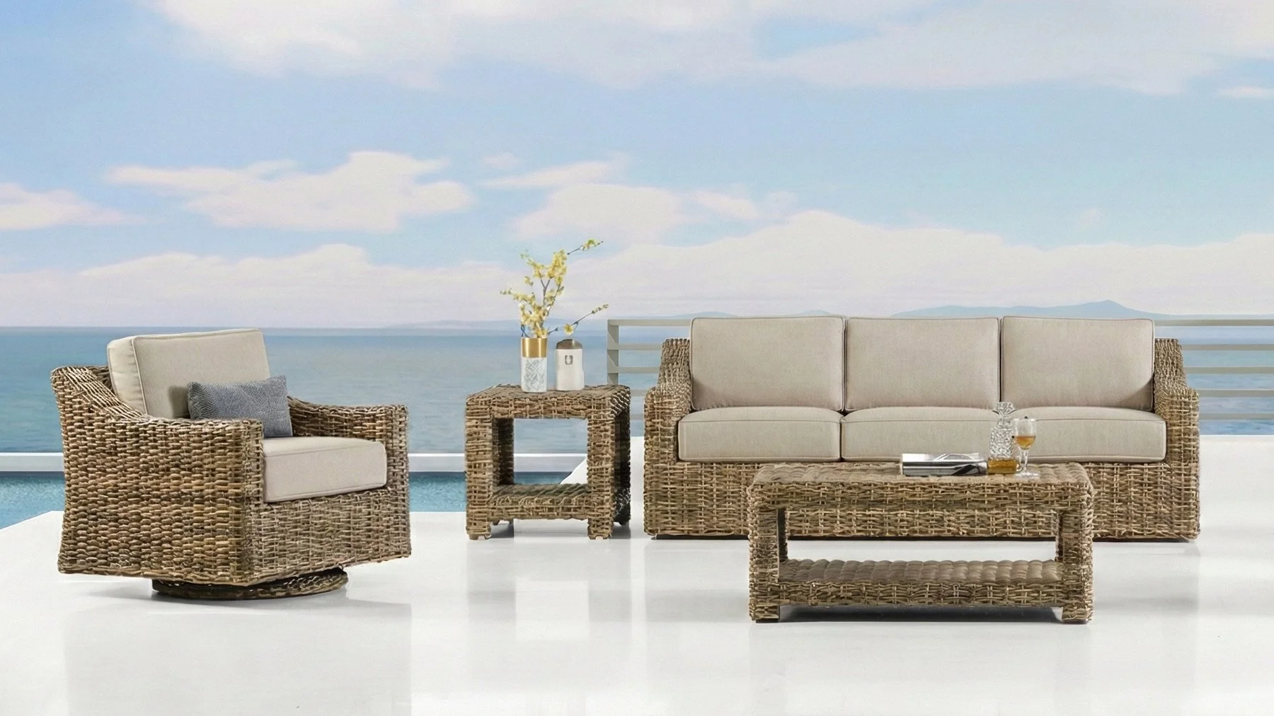 Outdoor patio furniture set with brown wicker sofa, armchair, coffee table, and side table with a view of the ocean in the background, sunny day.
