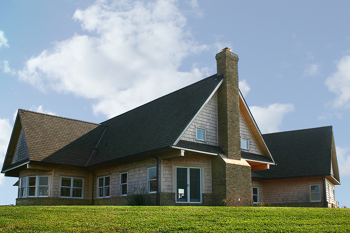 Cedar shingles over a brick watertable at a custom new home in Potomac .
