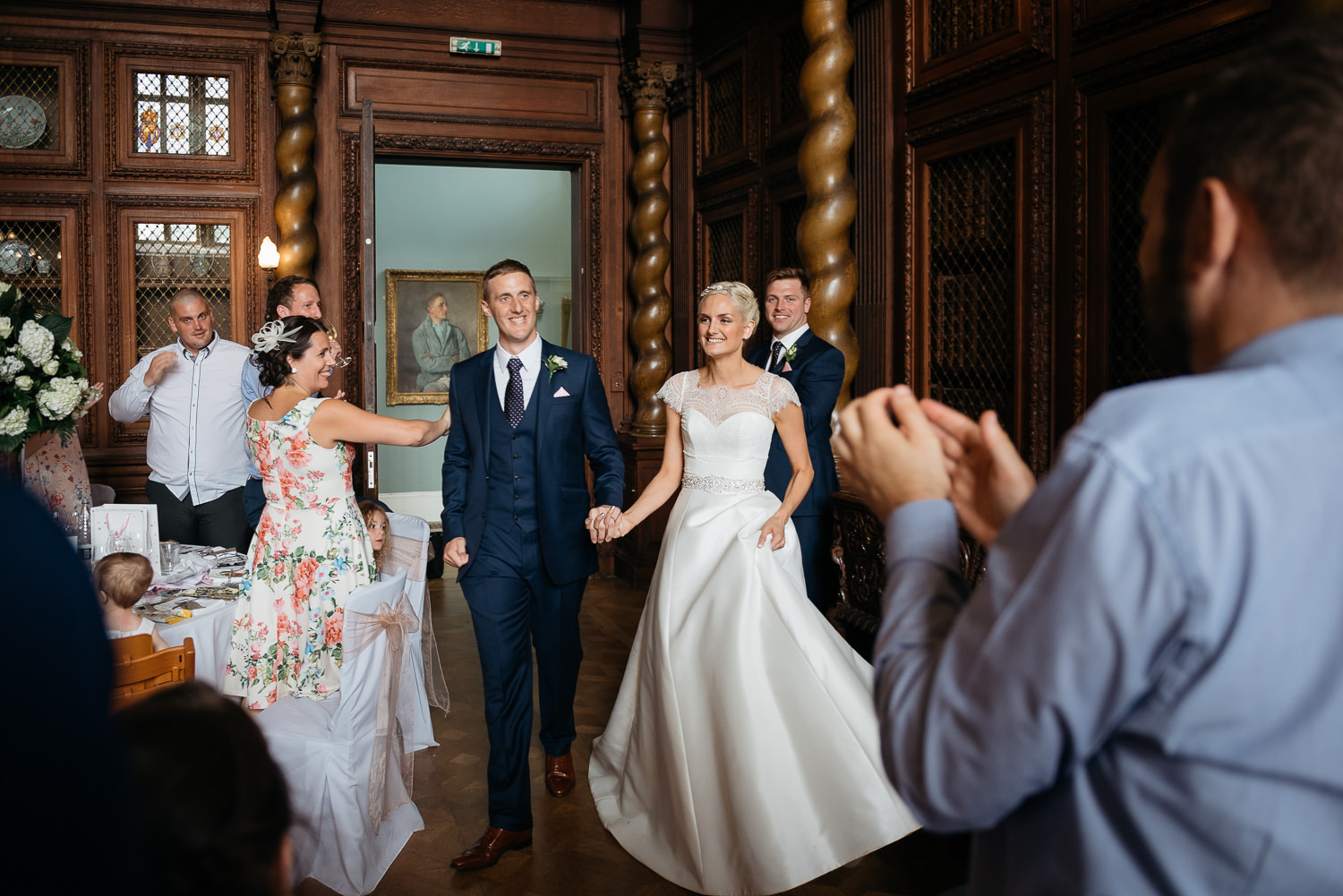 bride and grrom enter the great hall at burghley house