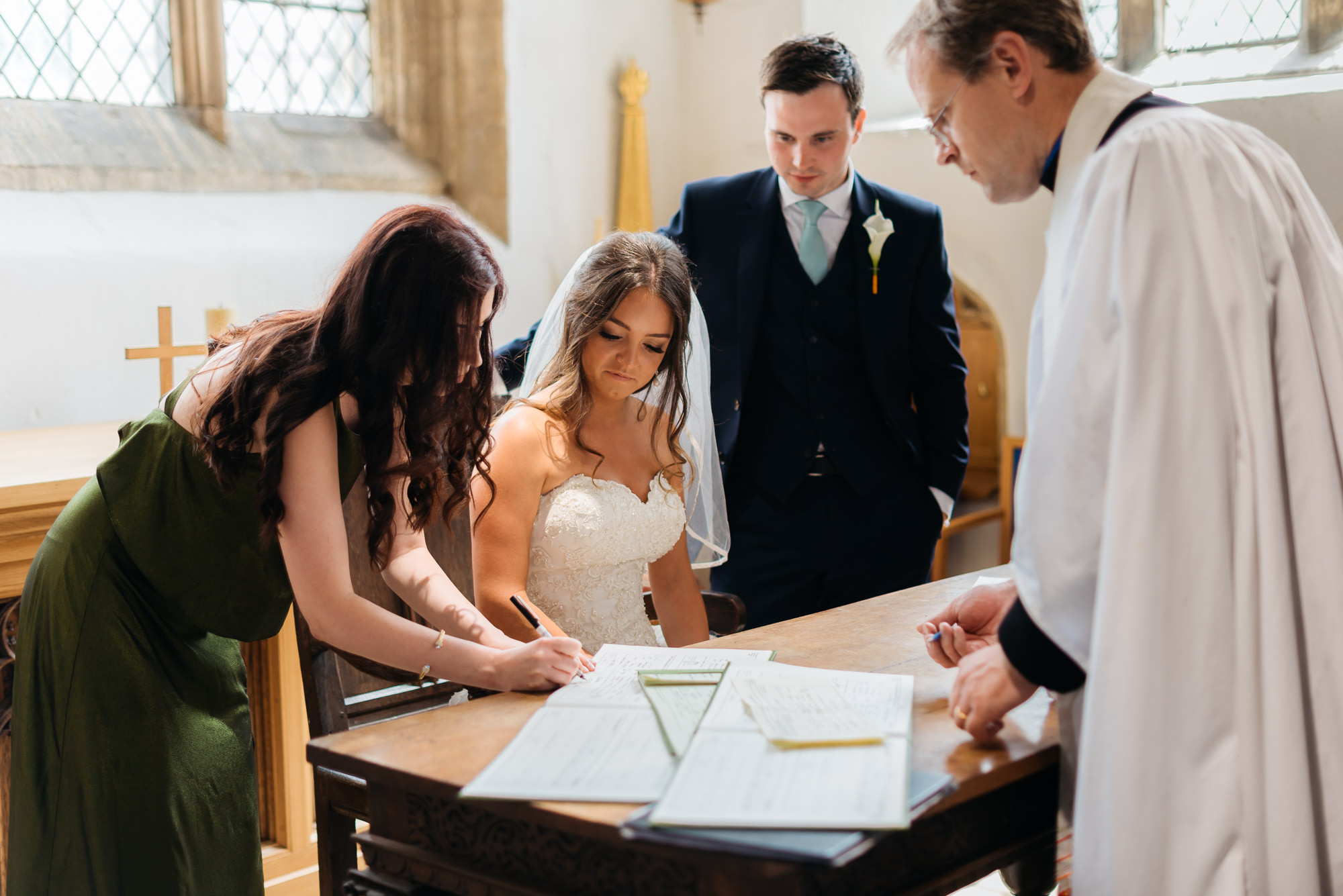 Bride signing the register at St Peters Church in Oundle