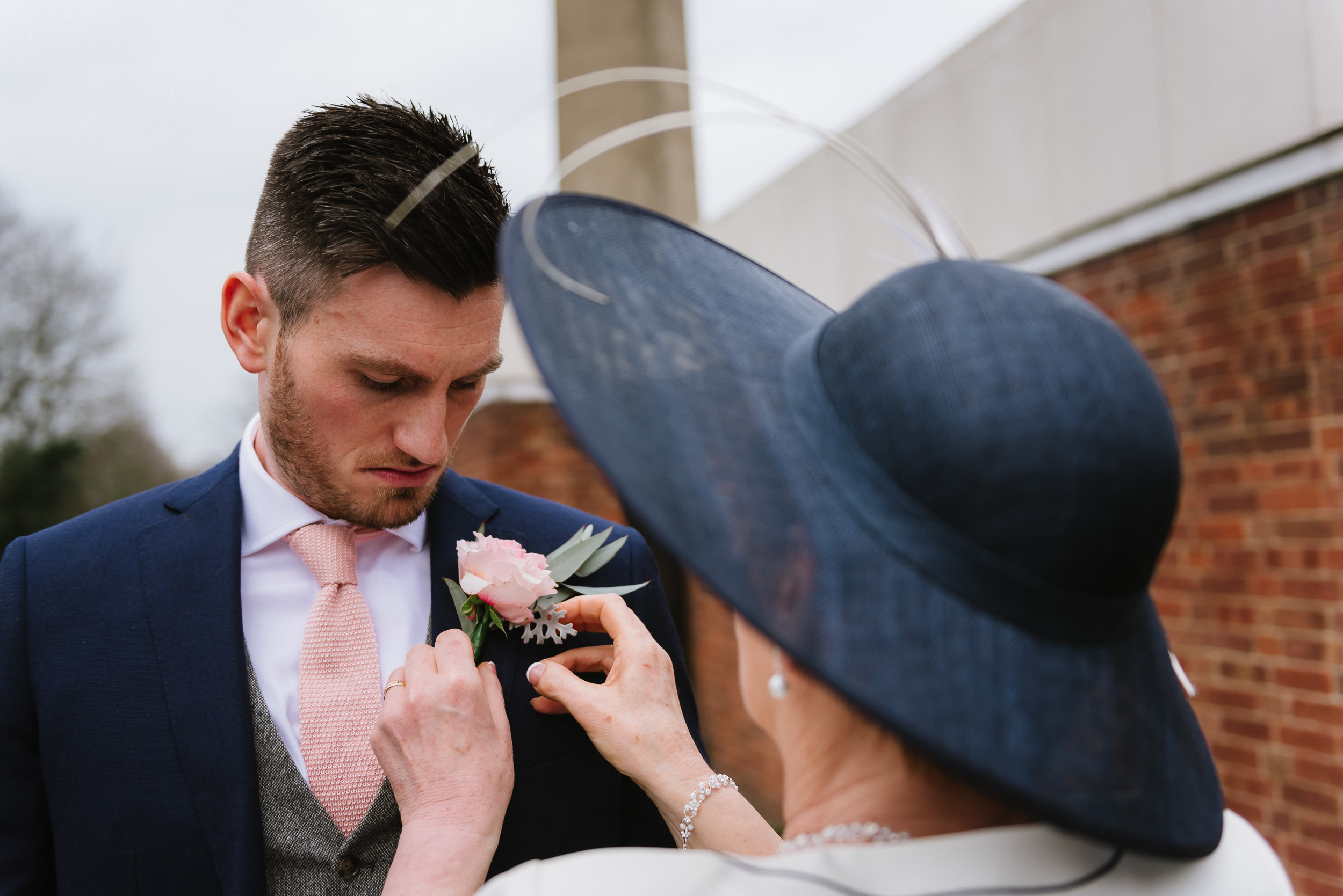 Grooms mother fixes his buttonhole