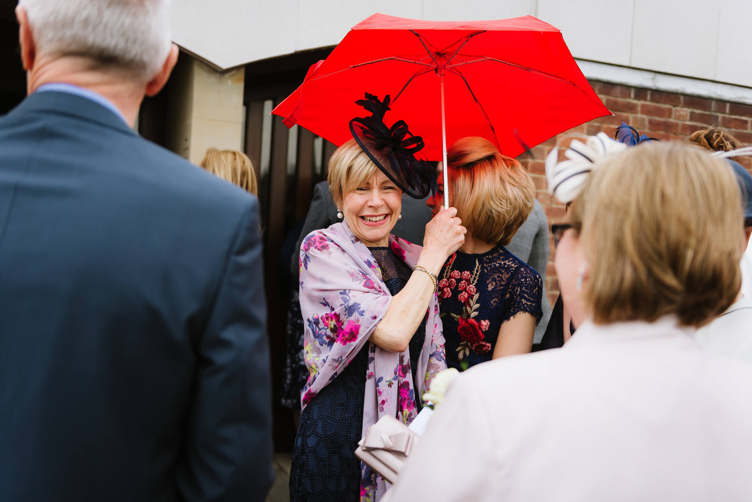 happy wedding guest with red umbrella