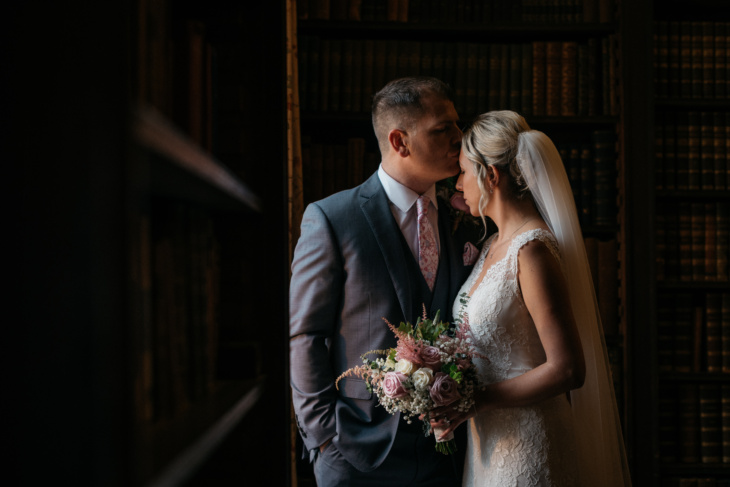 groom kisses brides forehead at Norwood park