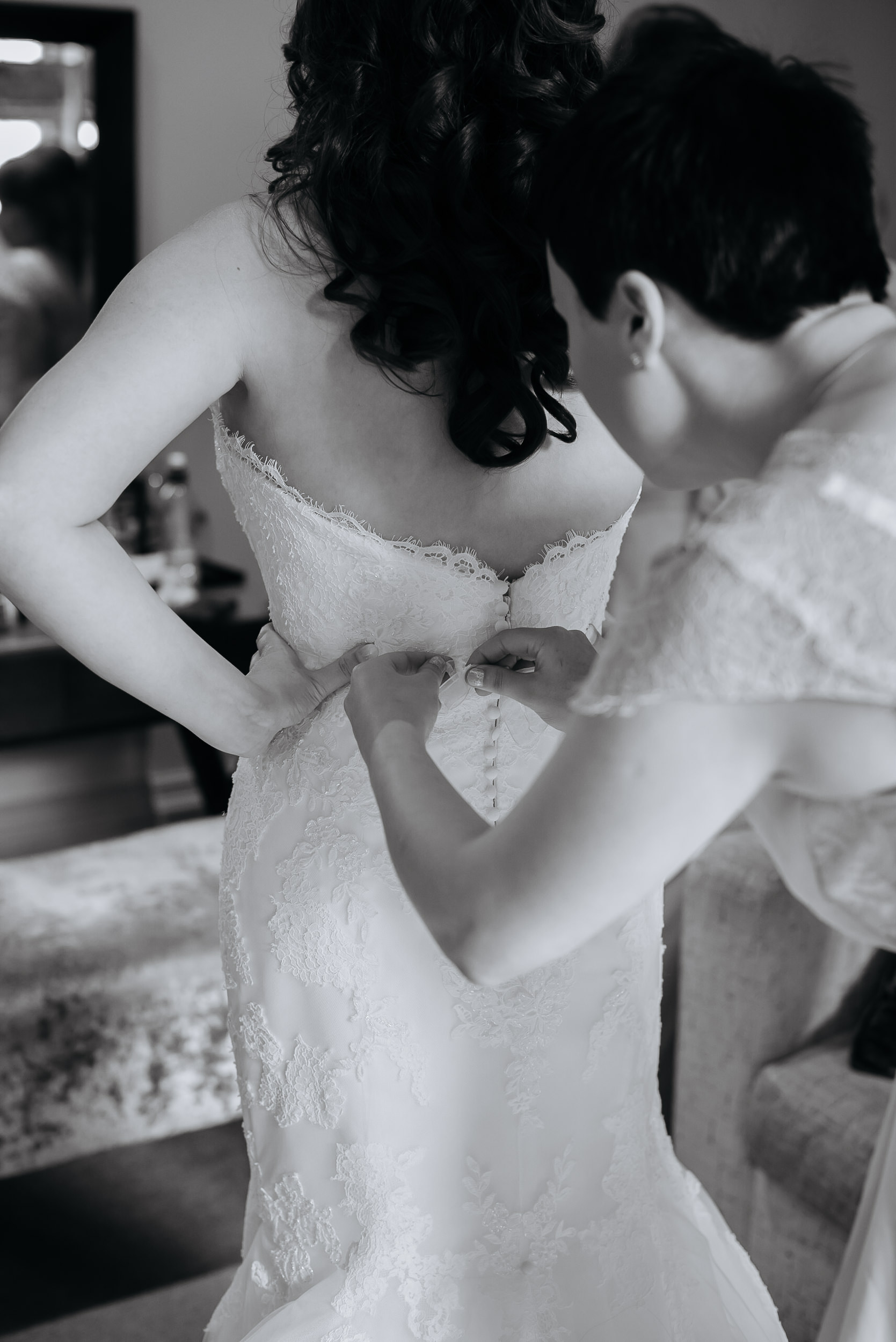 Fastening up the brides wedding dress