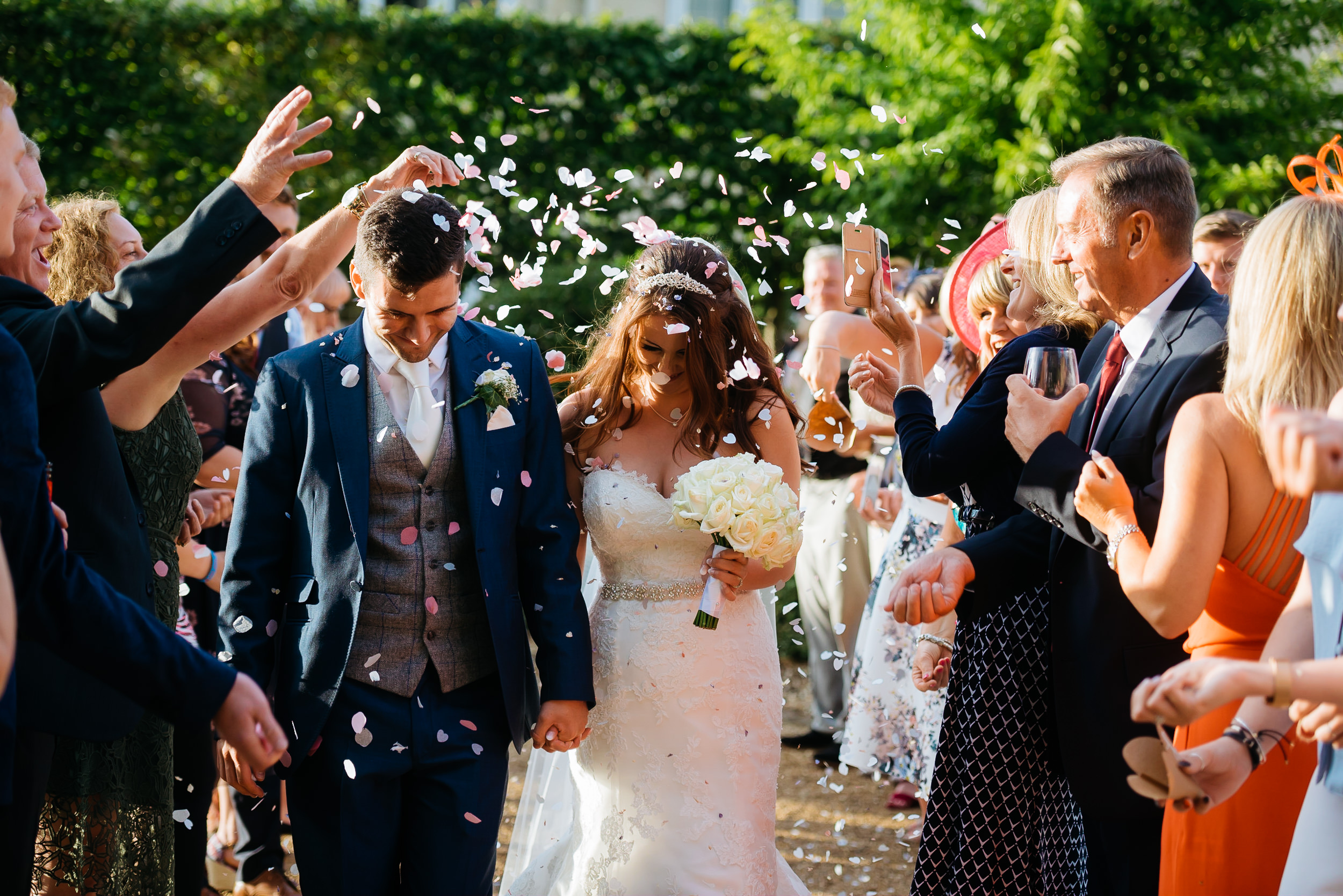 bride and groom having confetti thrown over them