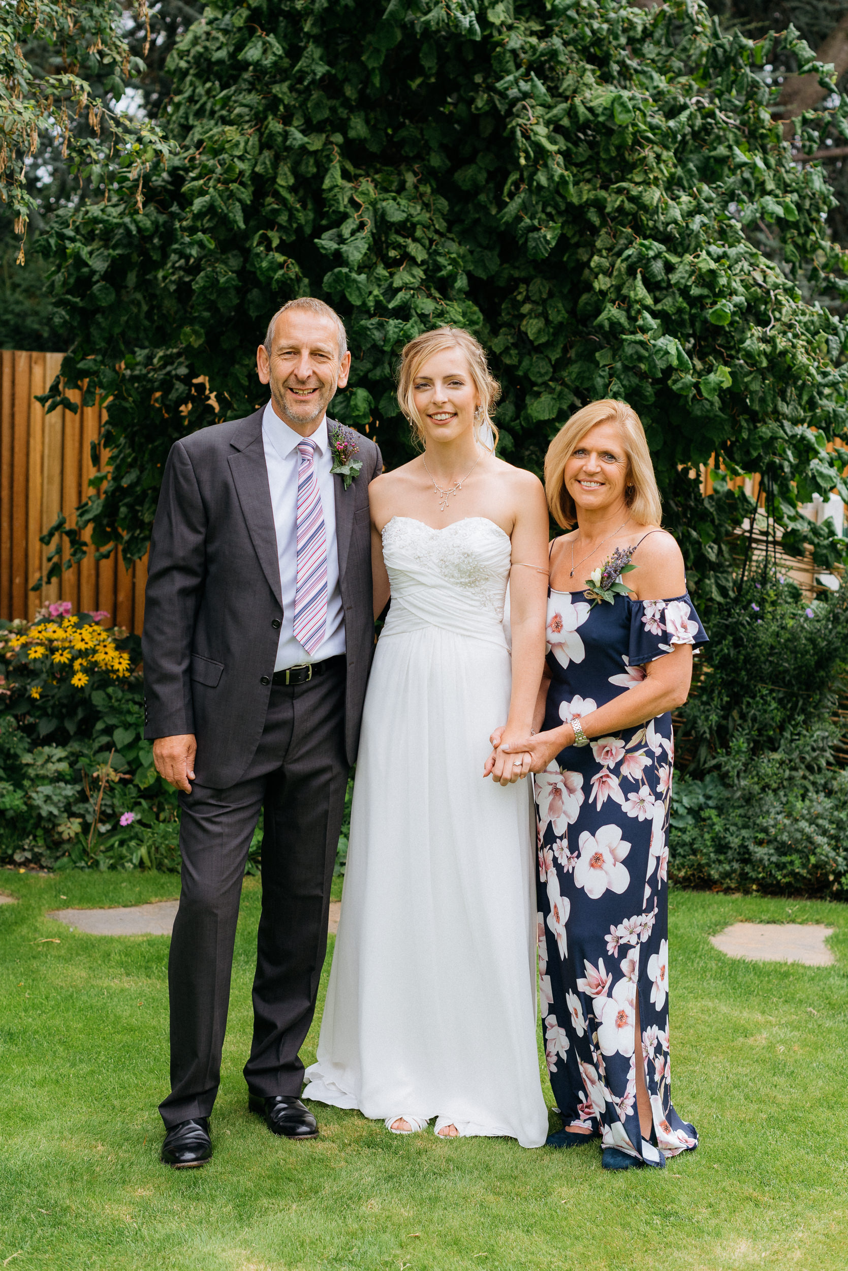 A photograph of the bride with her mother and father