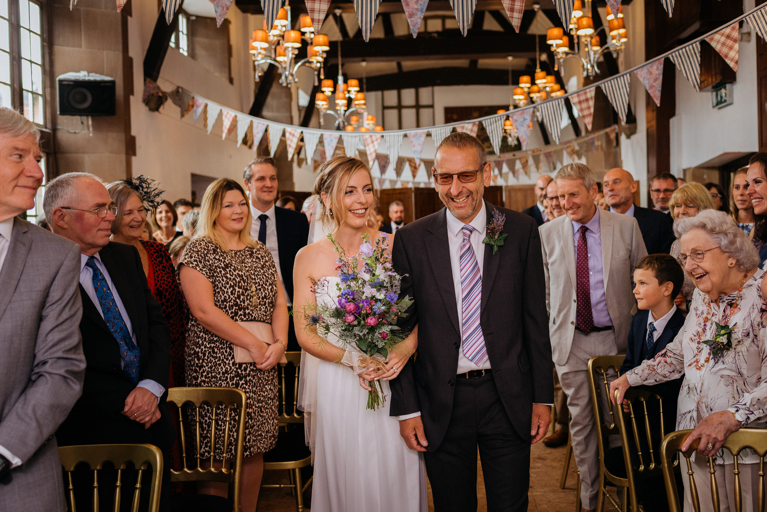 The bride and her father waslking down the aisle at Risley Hall