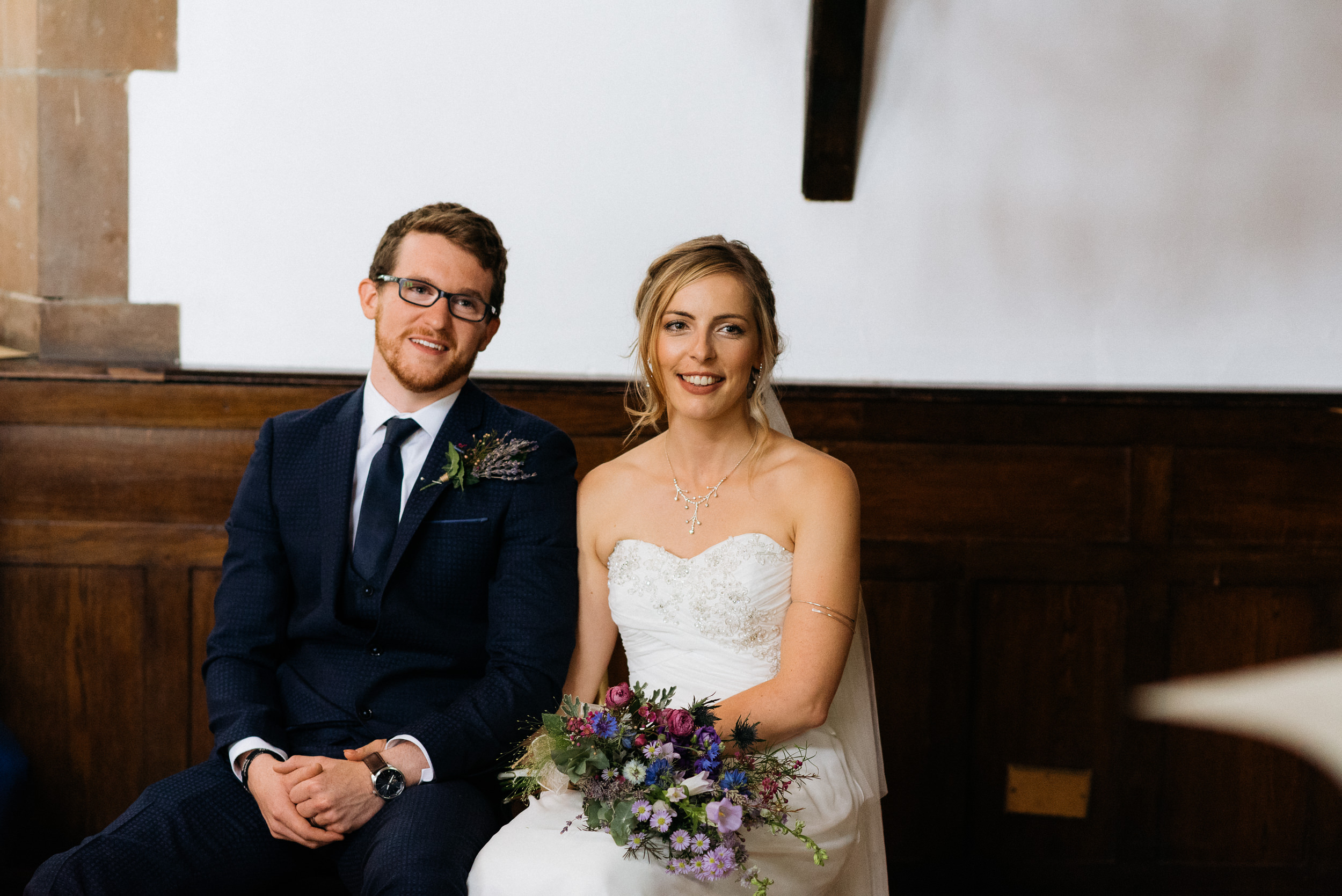 Bride and grrom listen to a speech at their wedding ceremony