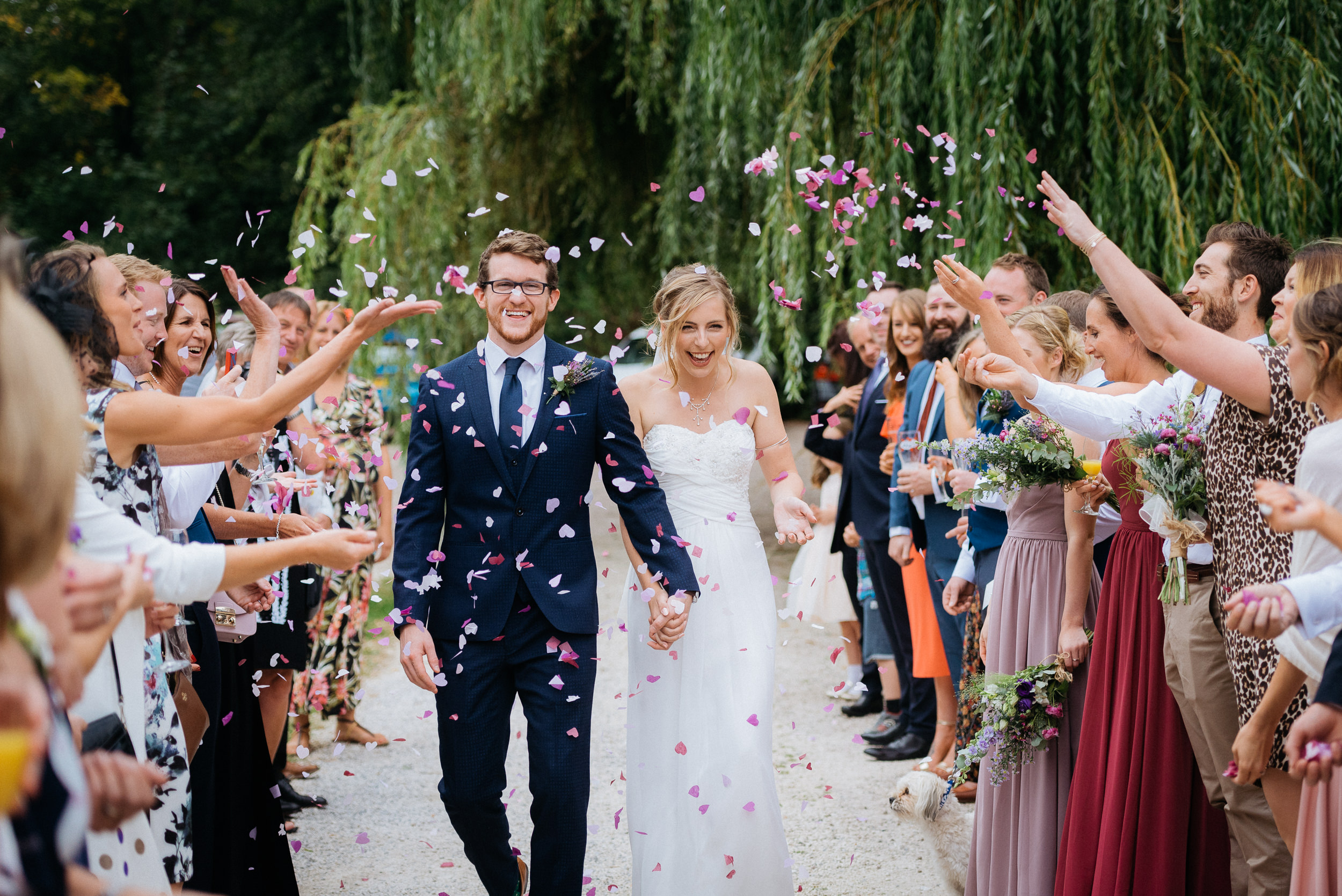 bride and groom have confetti thrown over them at Risley Hall