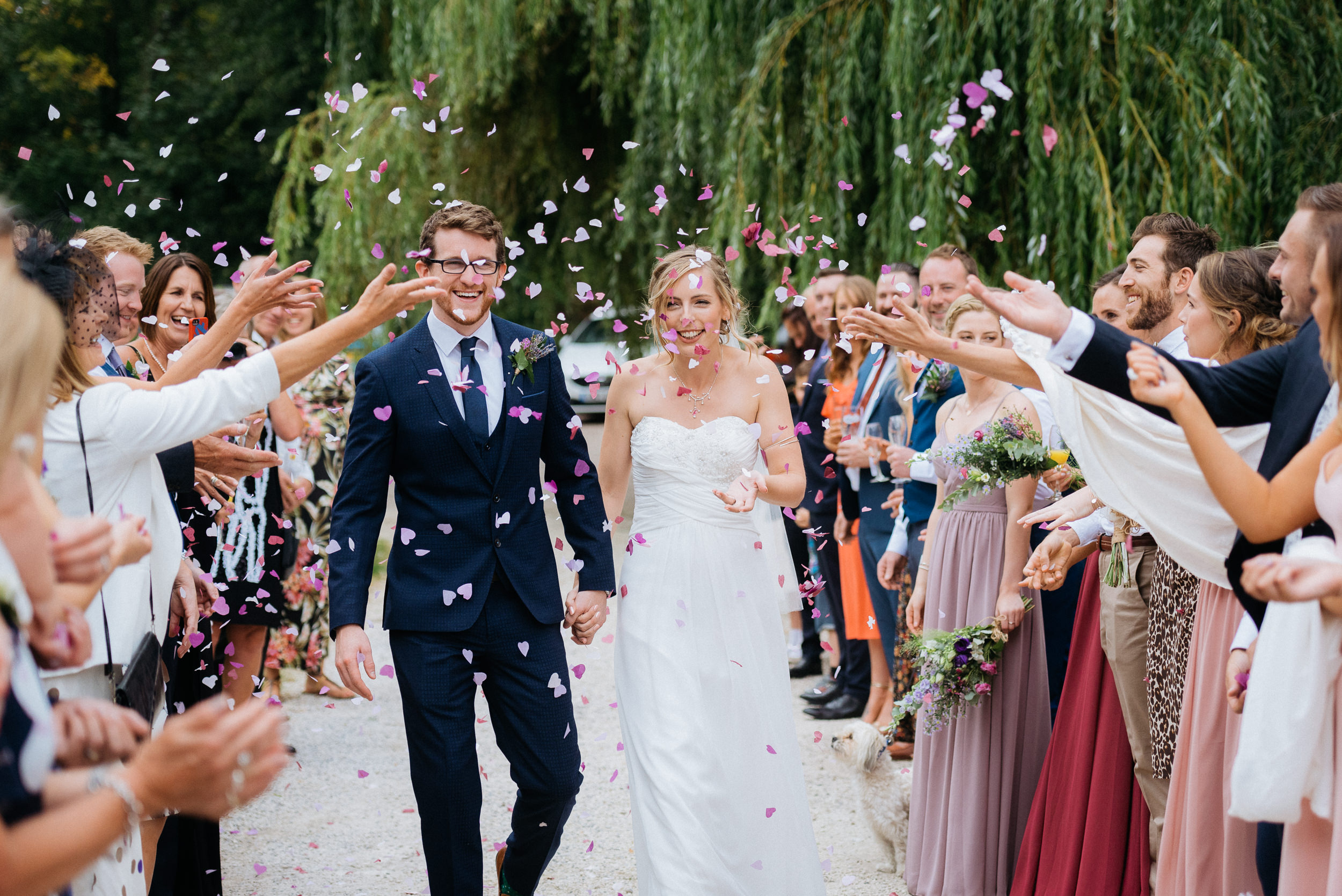 Bride and groom loving the confetti being thrown over them at Risley Hall