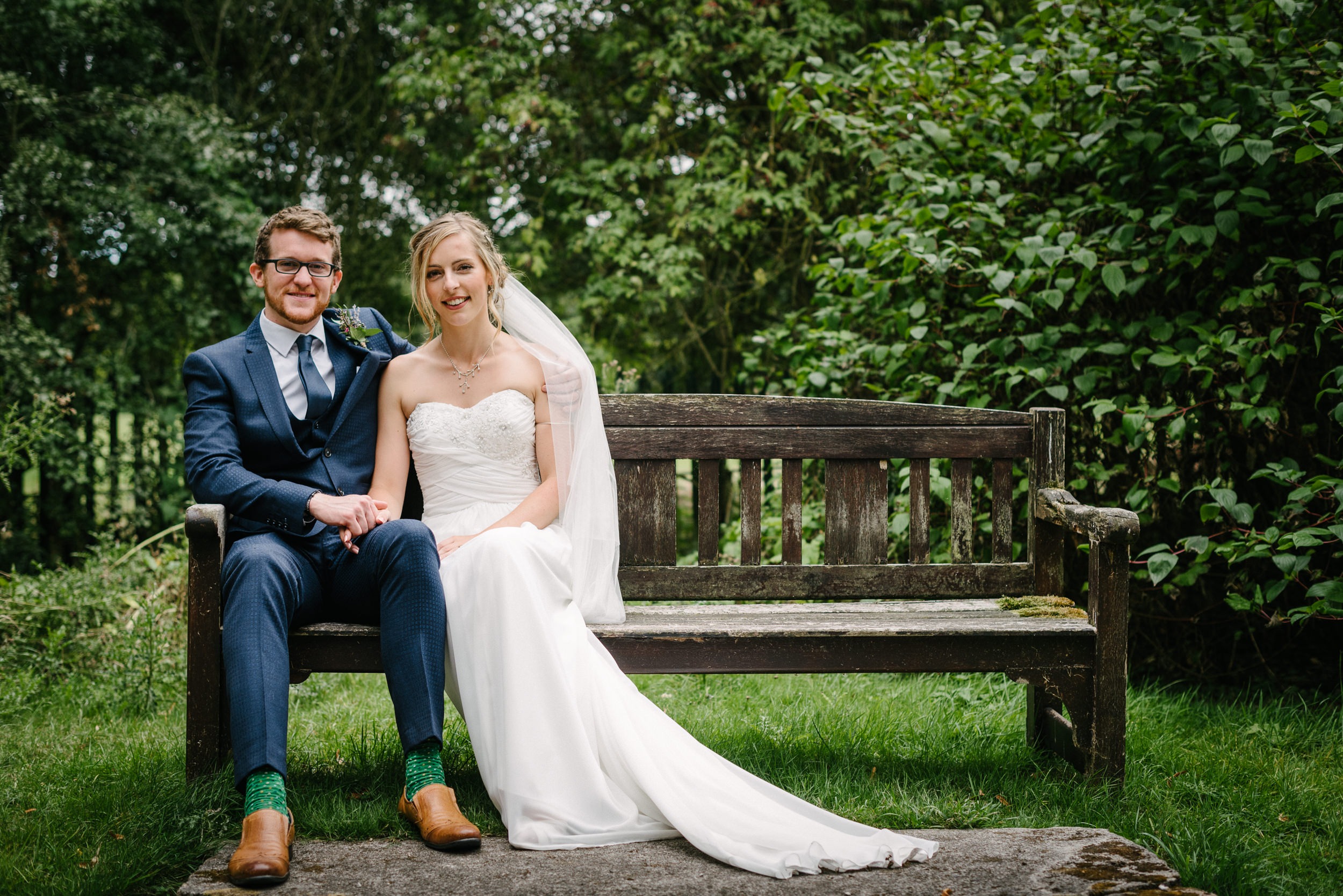 bride and groom on the bench at Risley Hall