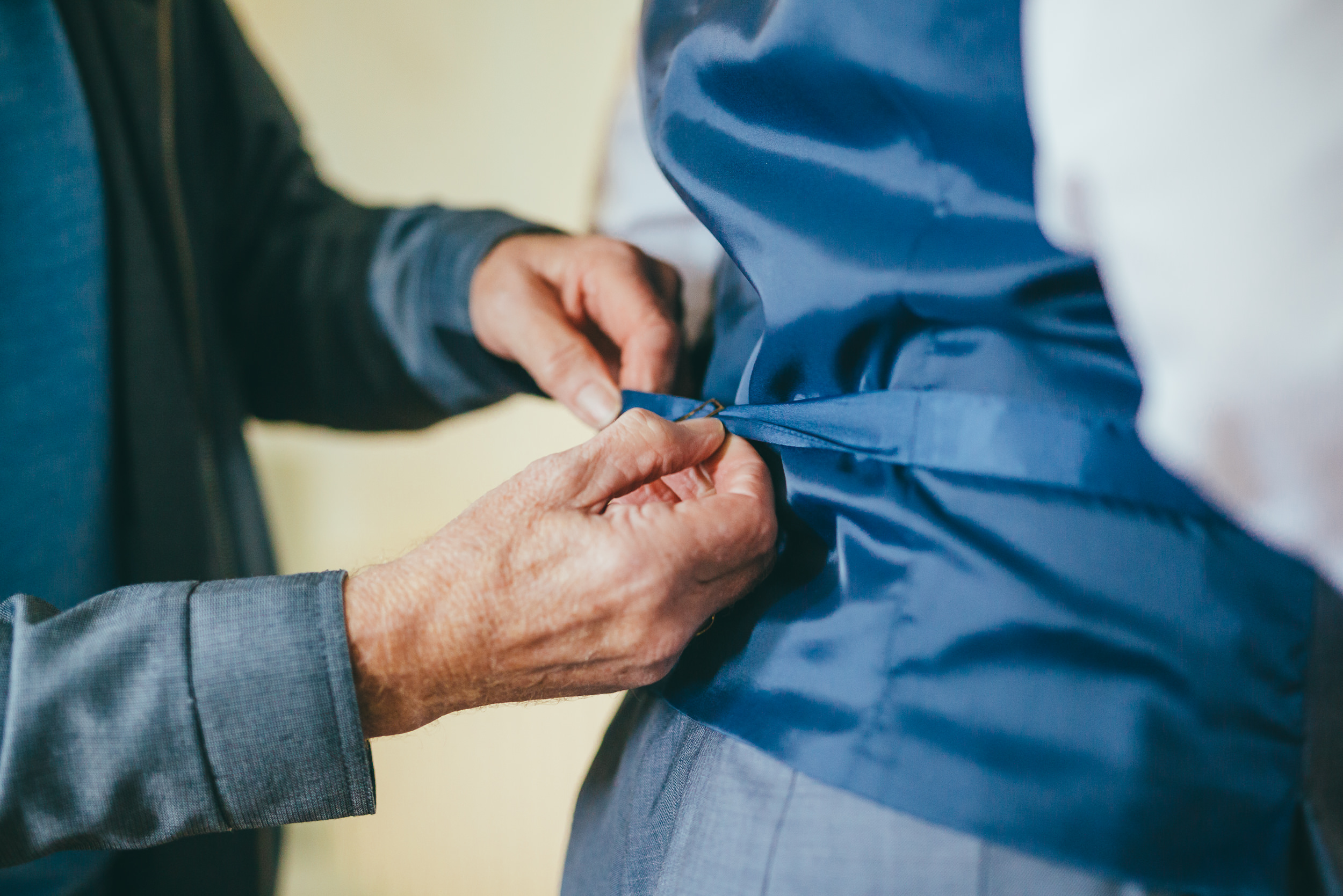 Groom putting on his waistcoat