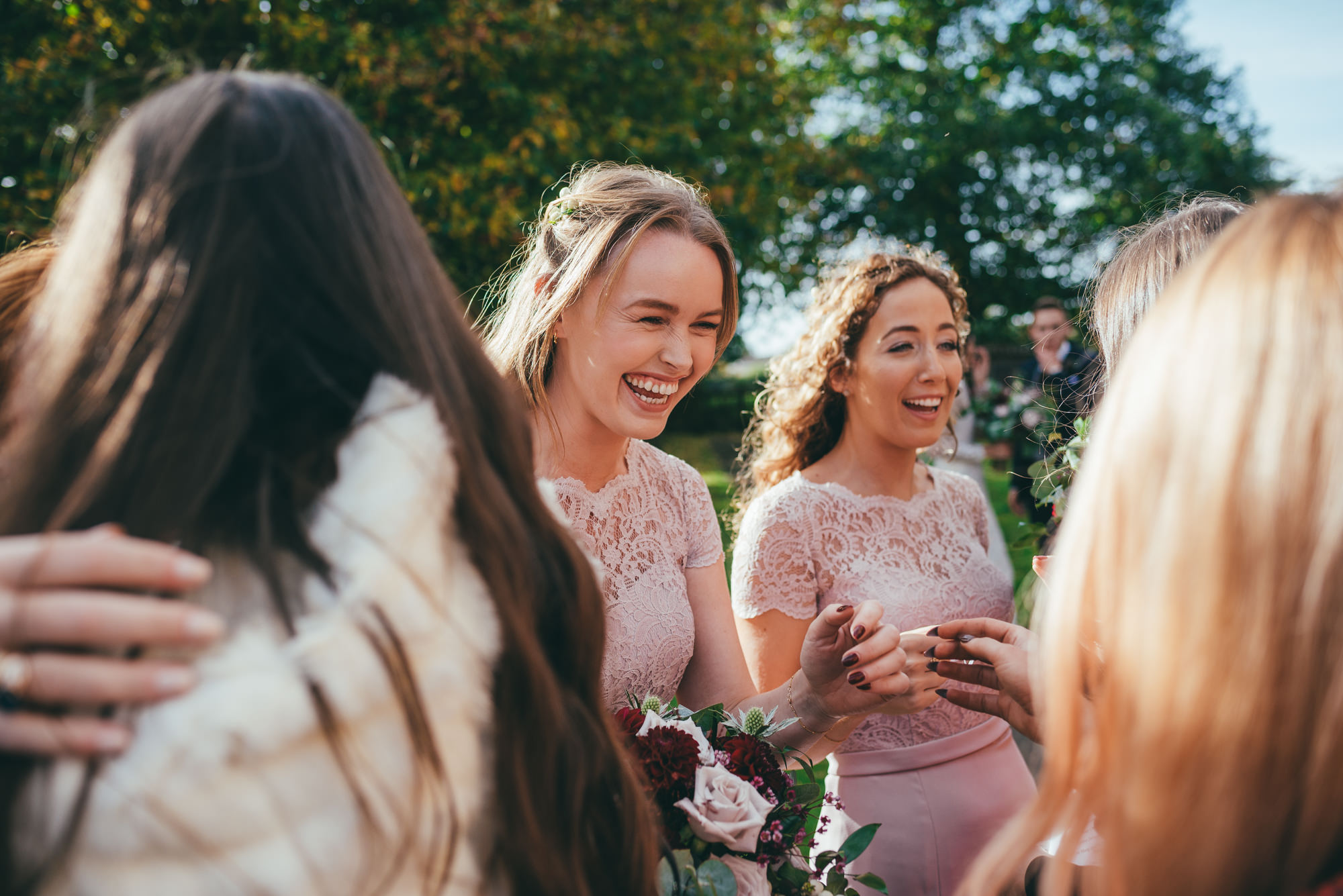 bridesmaids share a joke with the wedding guests