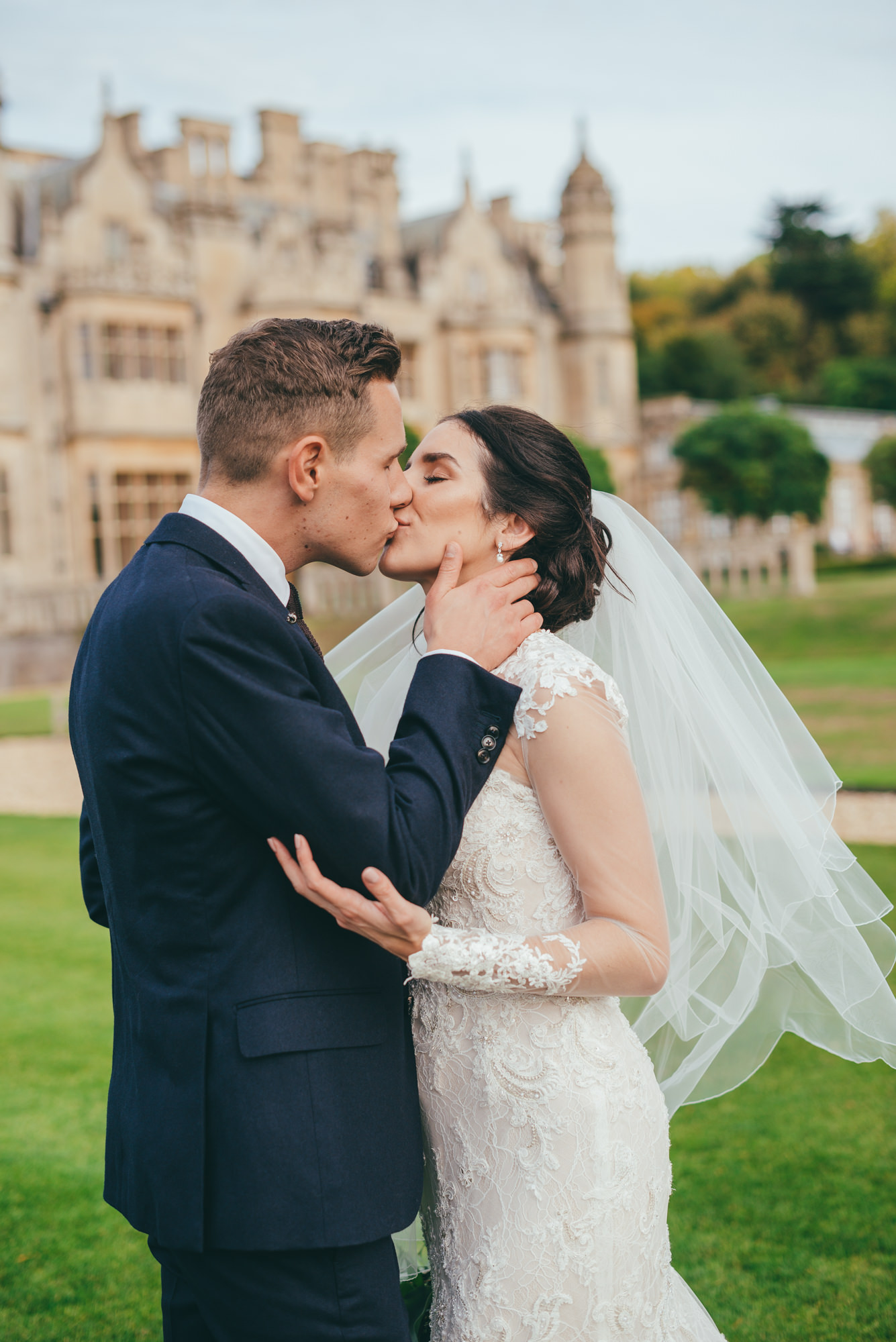bride and groom kissing on the lawns at harlaxton manor
