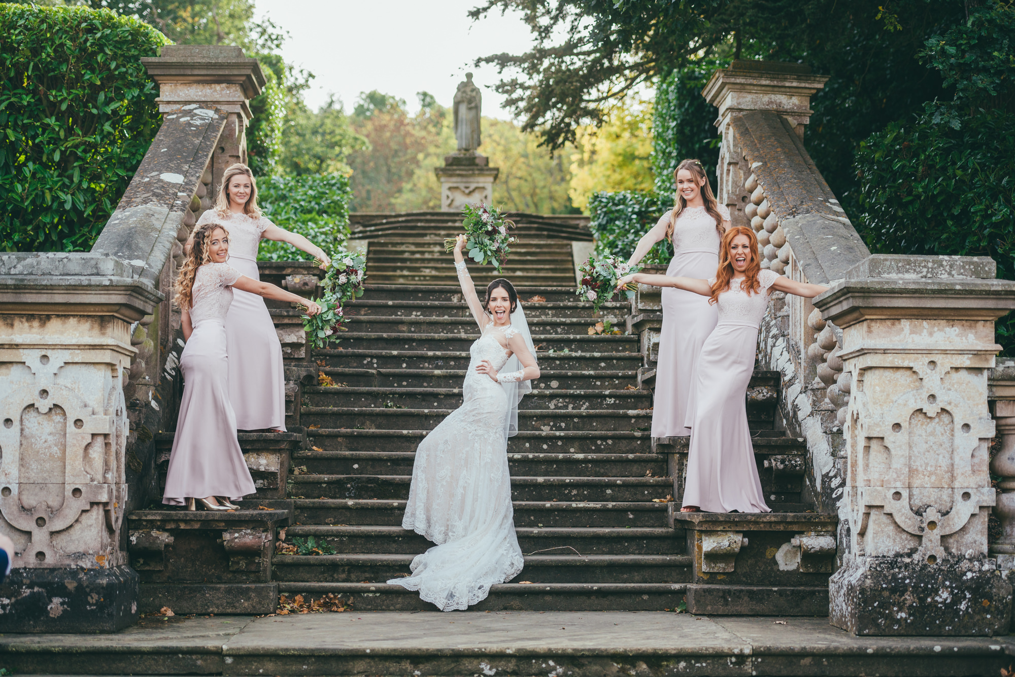bridesmaids having fun on the steps at harlaxton manor