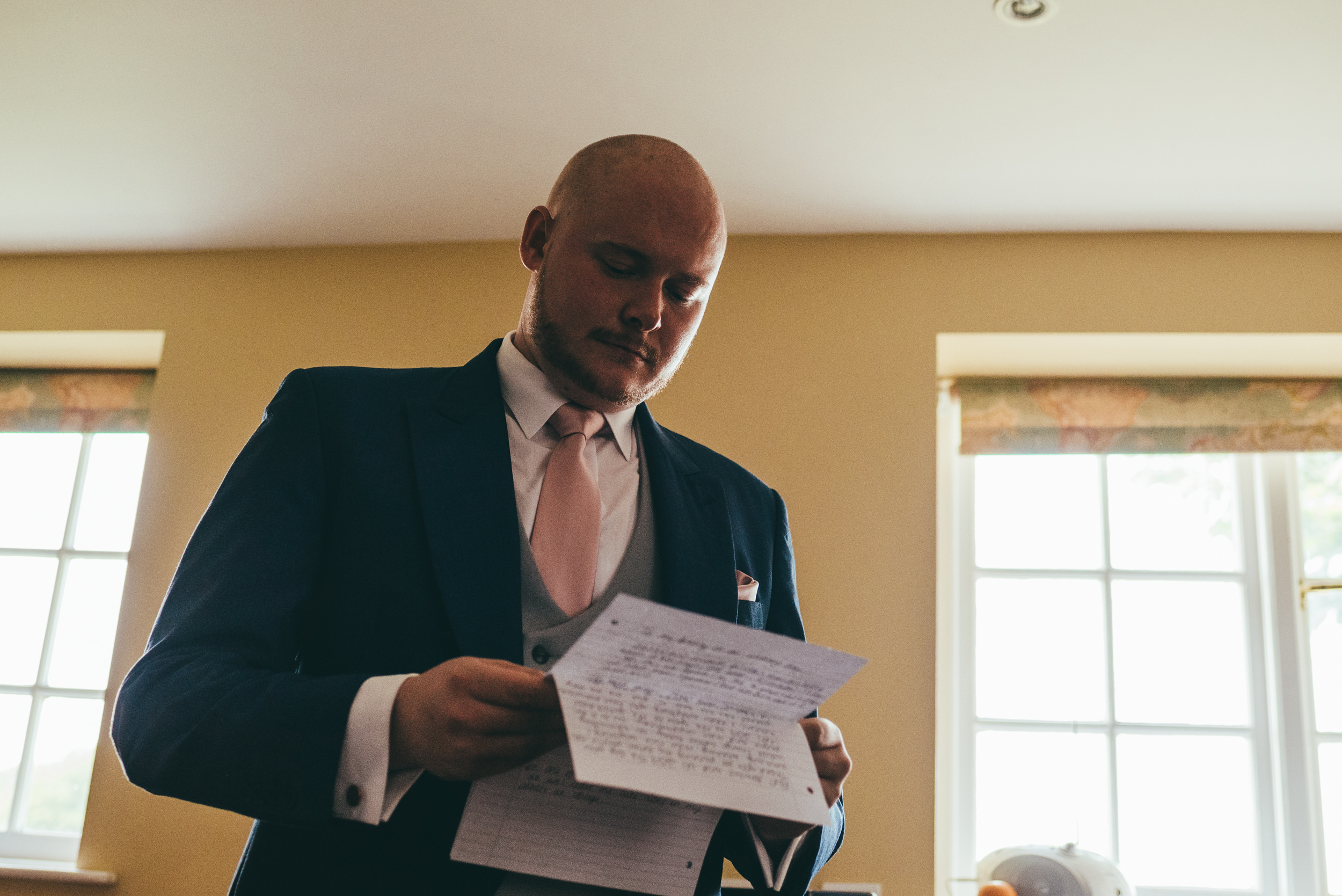 groom reading a letter from his wife to be