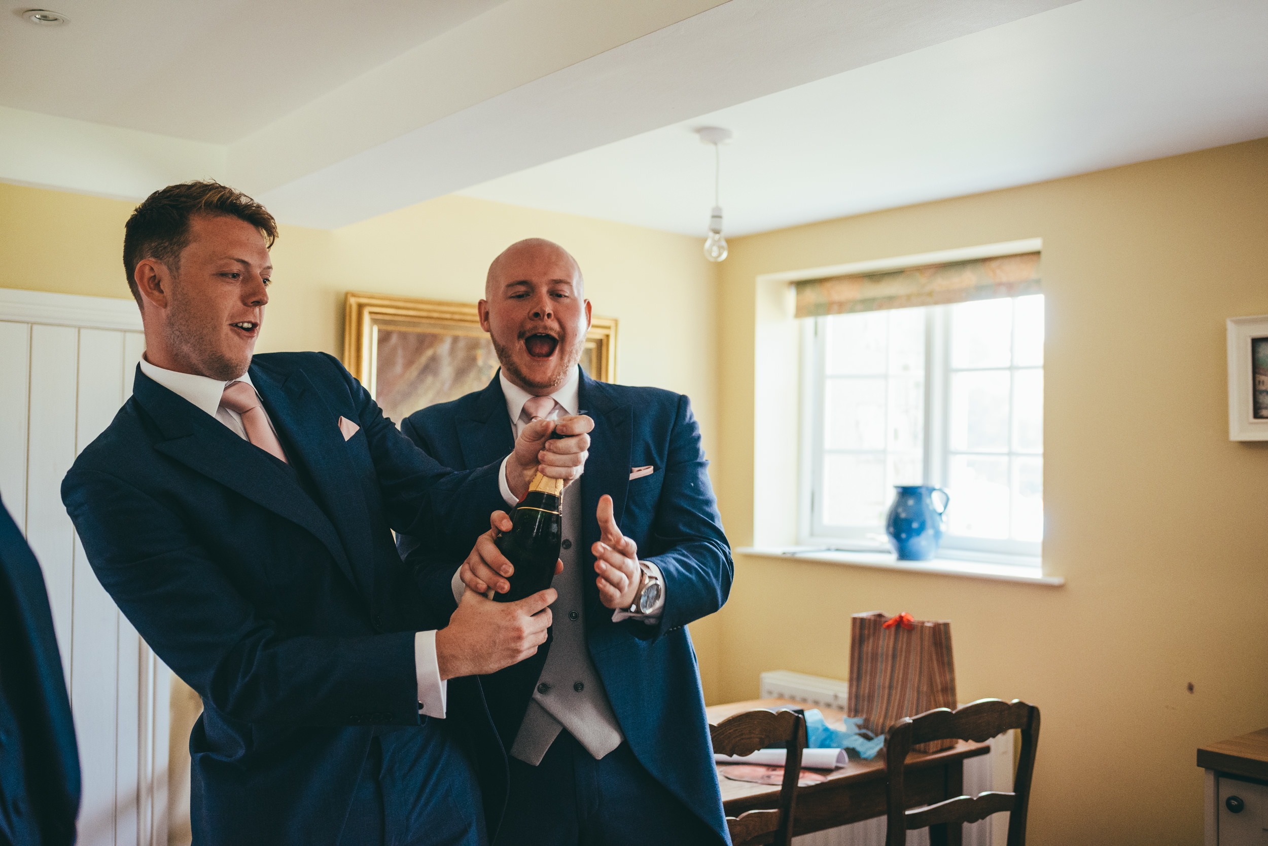 bestman opening a bottle of champagne