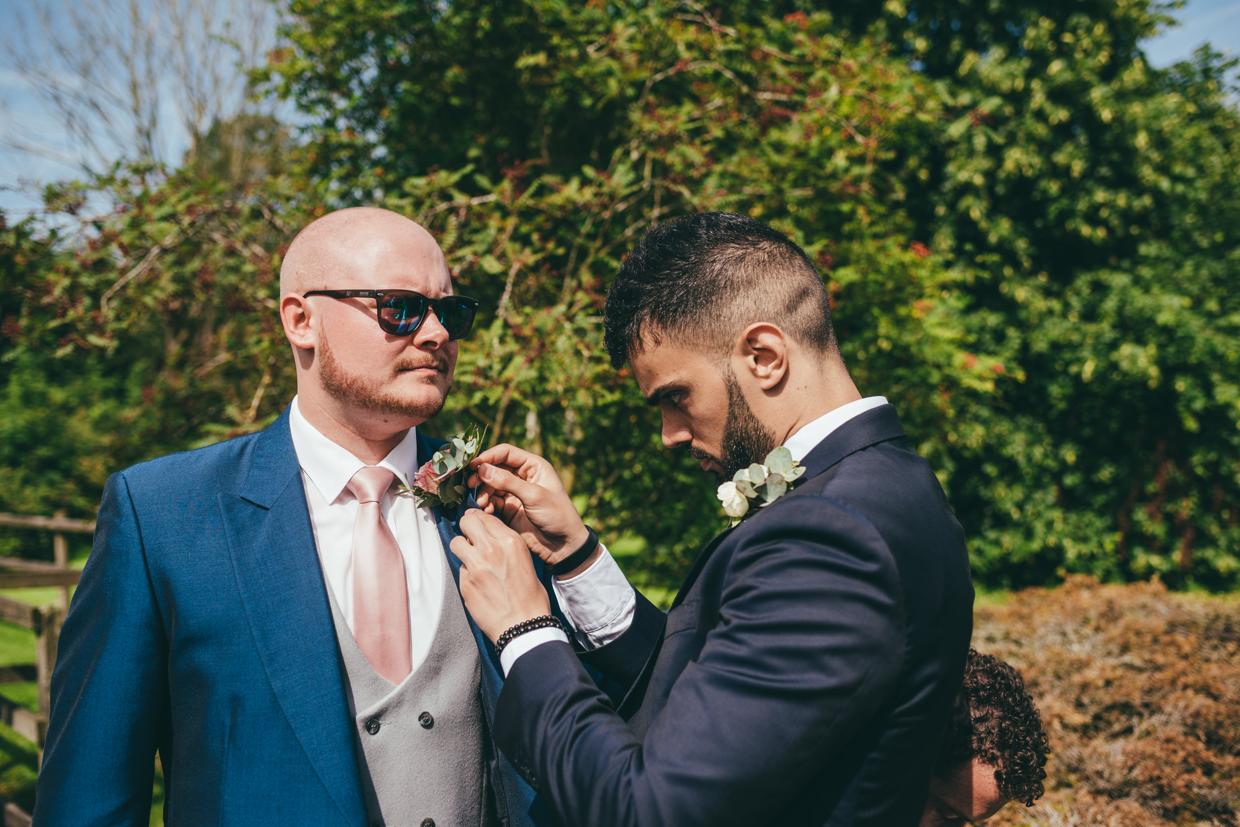 groom having his buttonhole flower put in