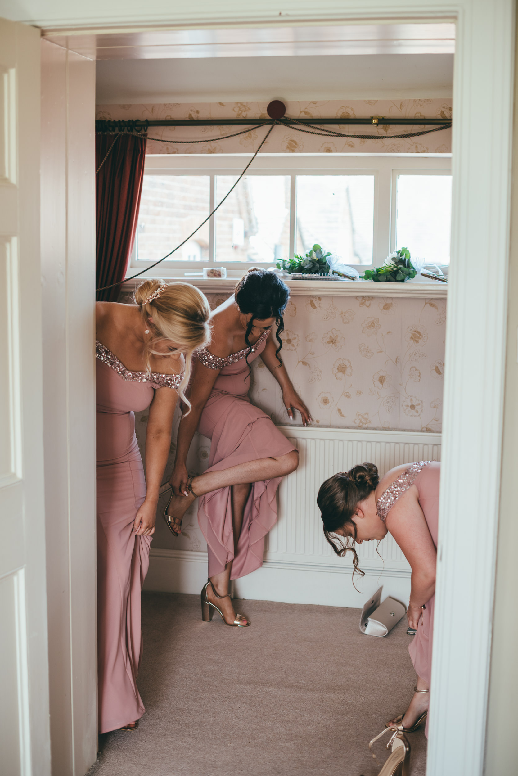 bridesmaids fixing their shoe straps