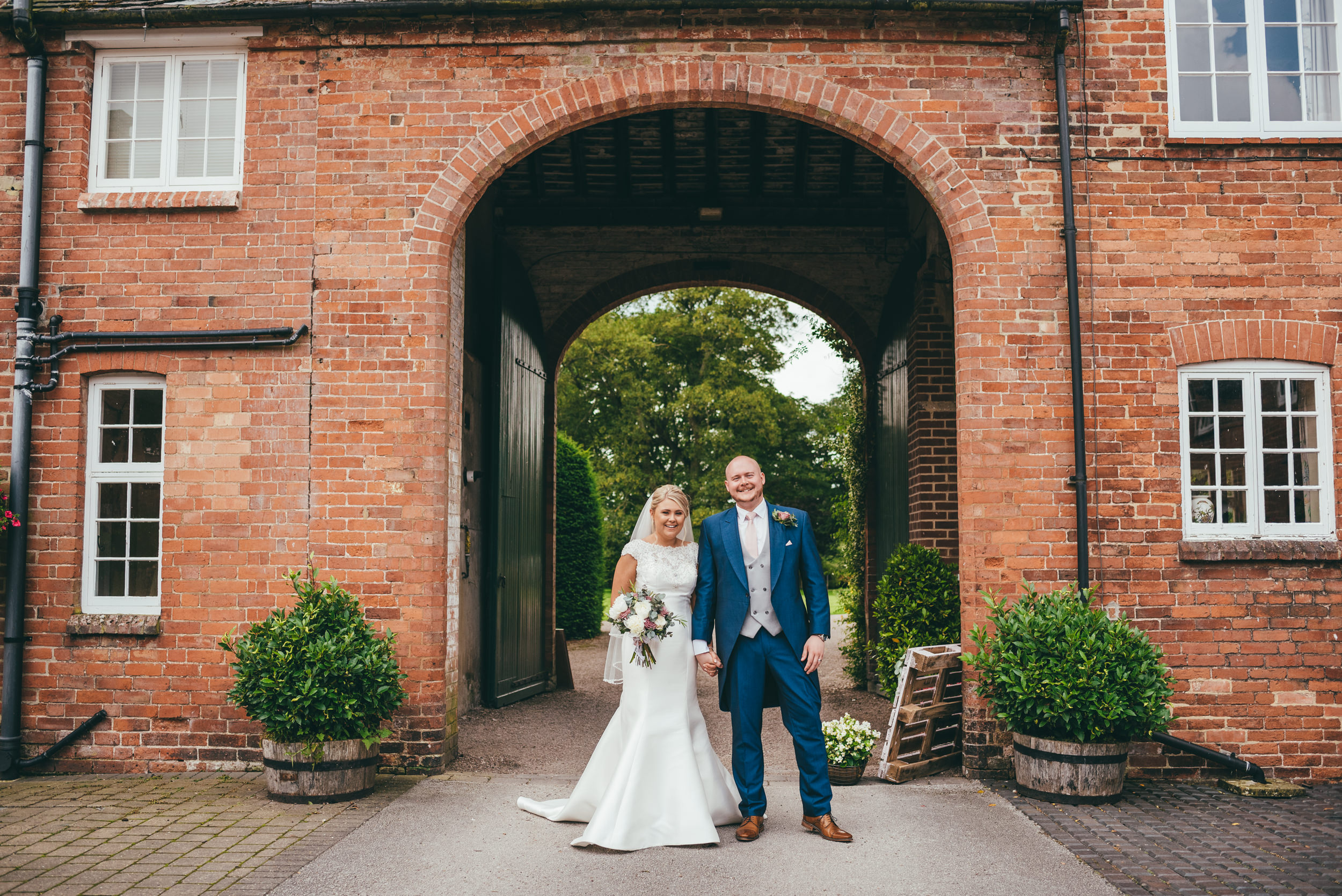 bride and groom under the archway at yeldersley hall