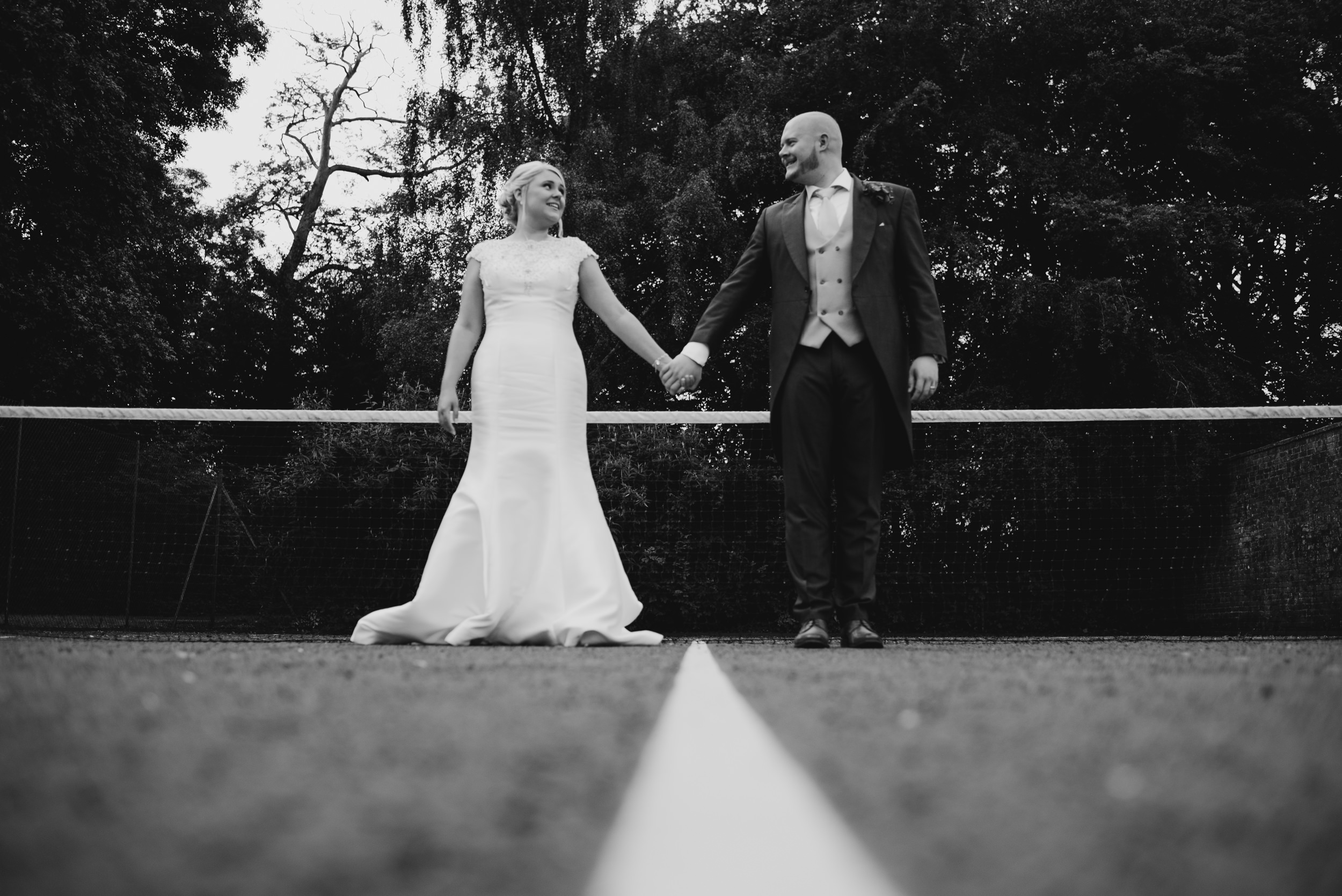 portriat of the bride and groom on a tennis court