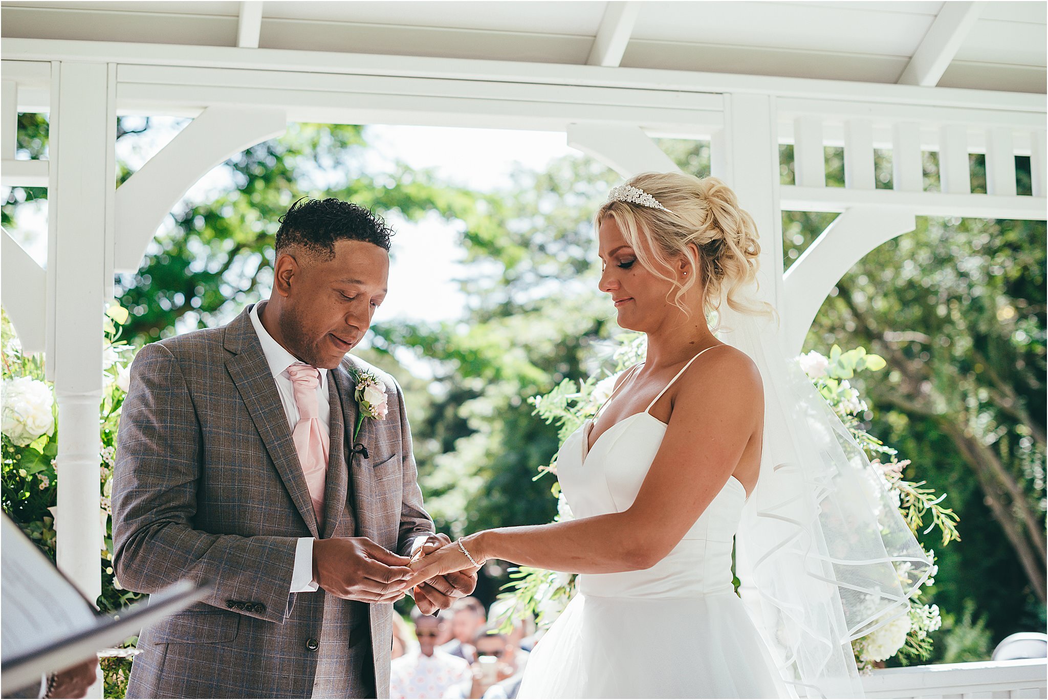 groom placing the wedding ring on the brides finger