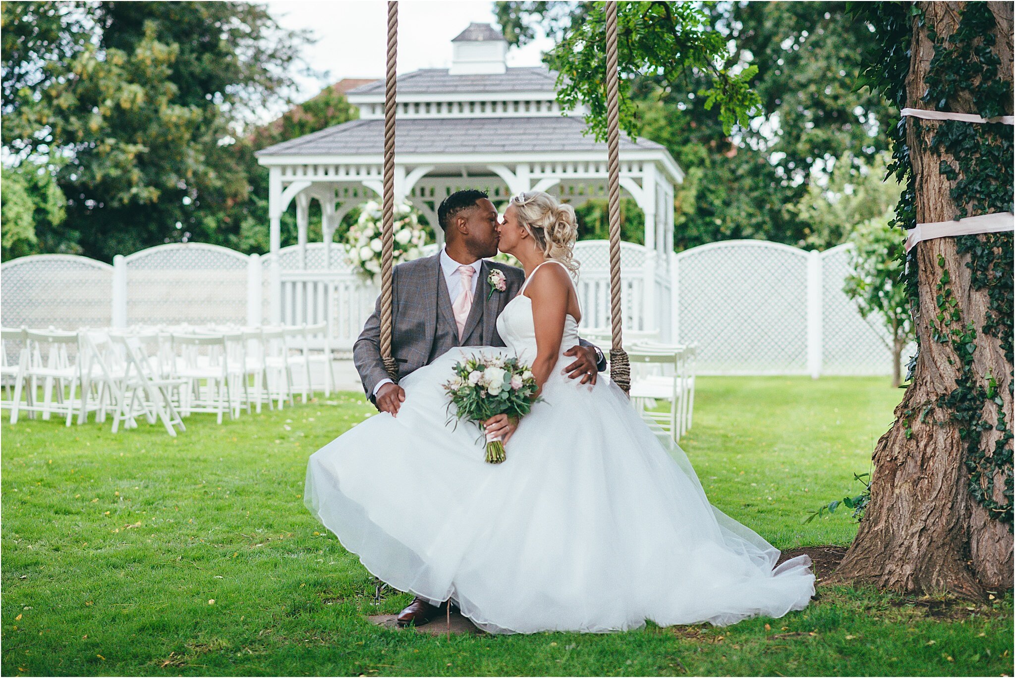 bride and groom kissing on a rope swing at the old vicarage boutique hotel