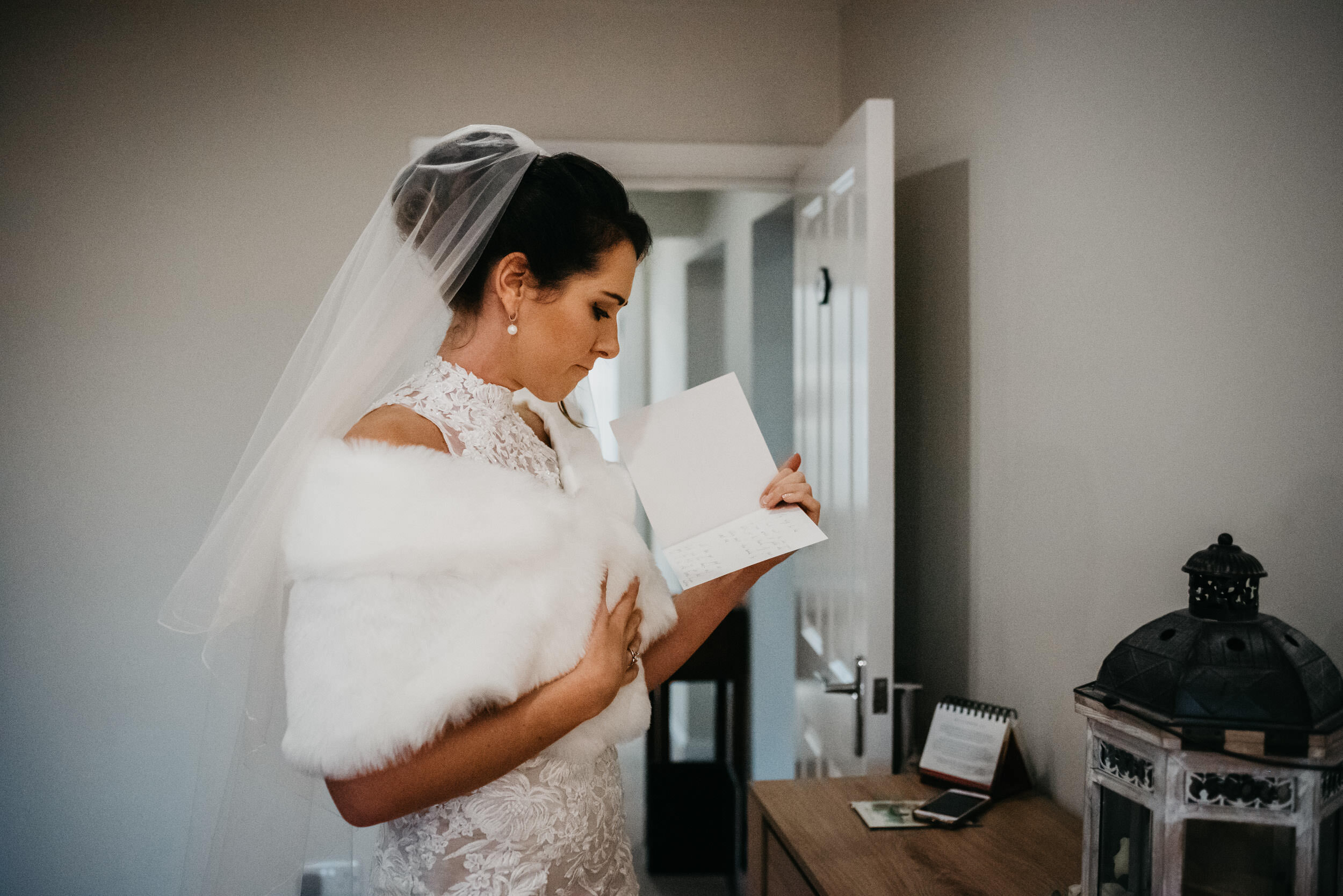 bride reading a wedding card from her husband to be 