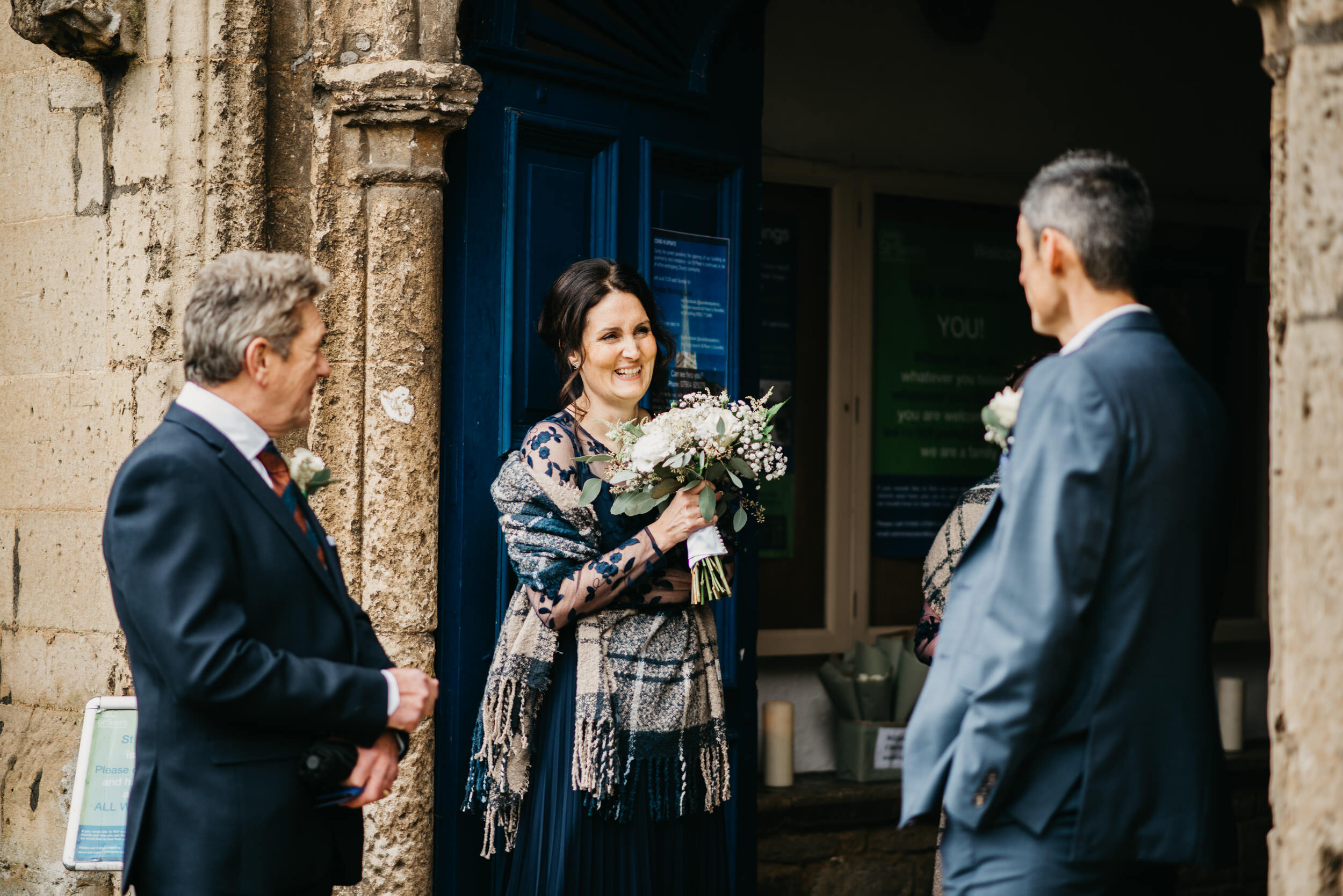 wedding guests joking at St Peters church in oundle