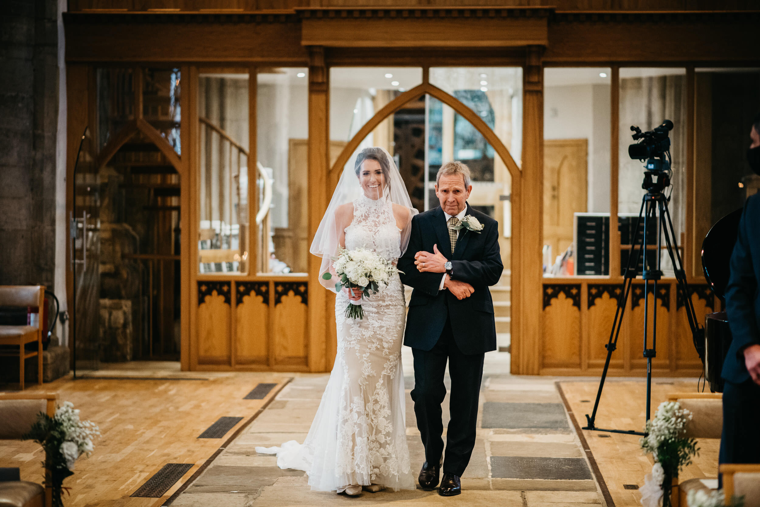 bride and her father walk down the aisle at St Peters Church in Oundle
