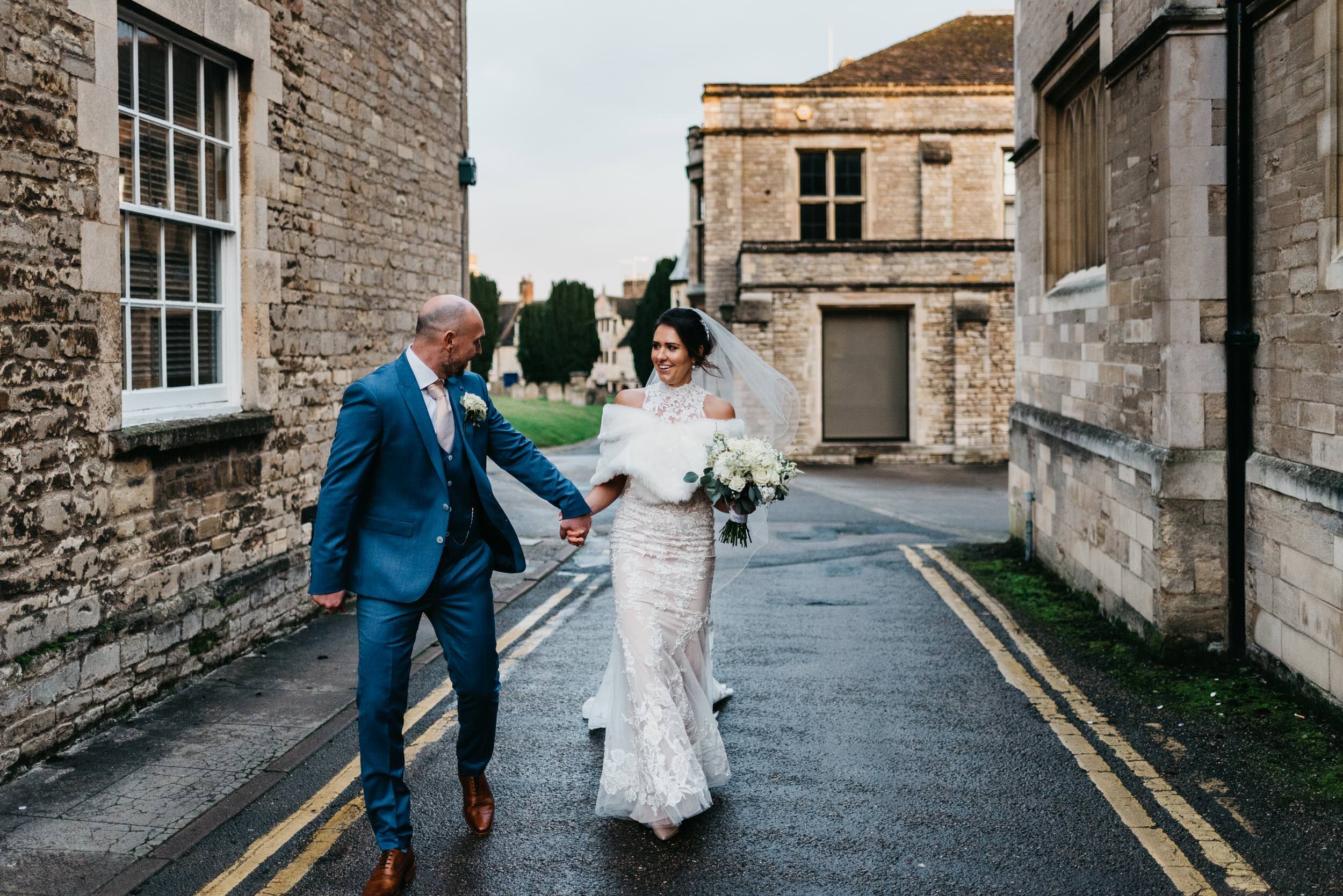 Portrait of the bride and grrom walking through the streets in Oundle