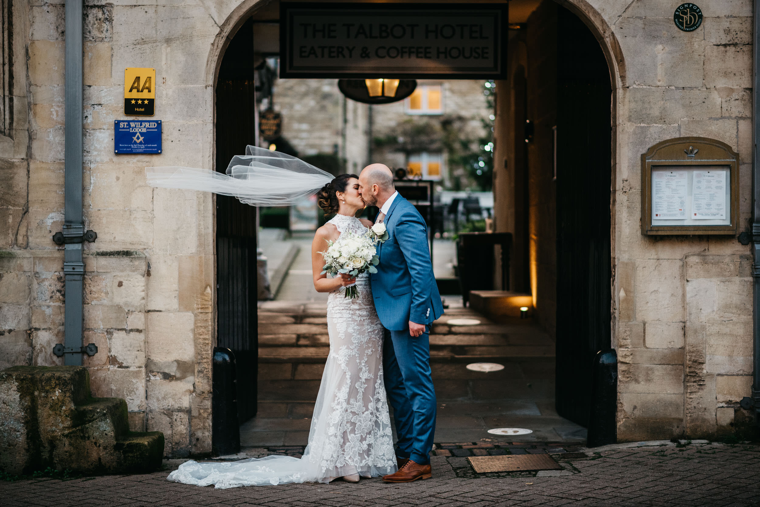 bride and groom kissing outside the Talbot Hotel in Oundle. 