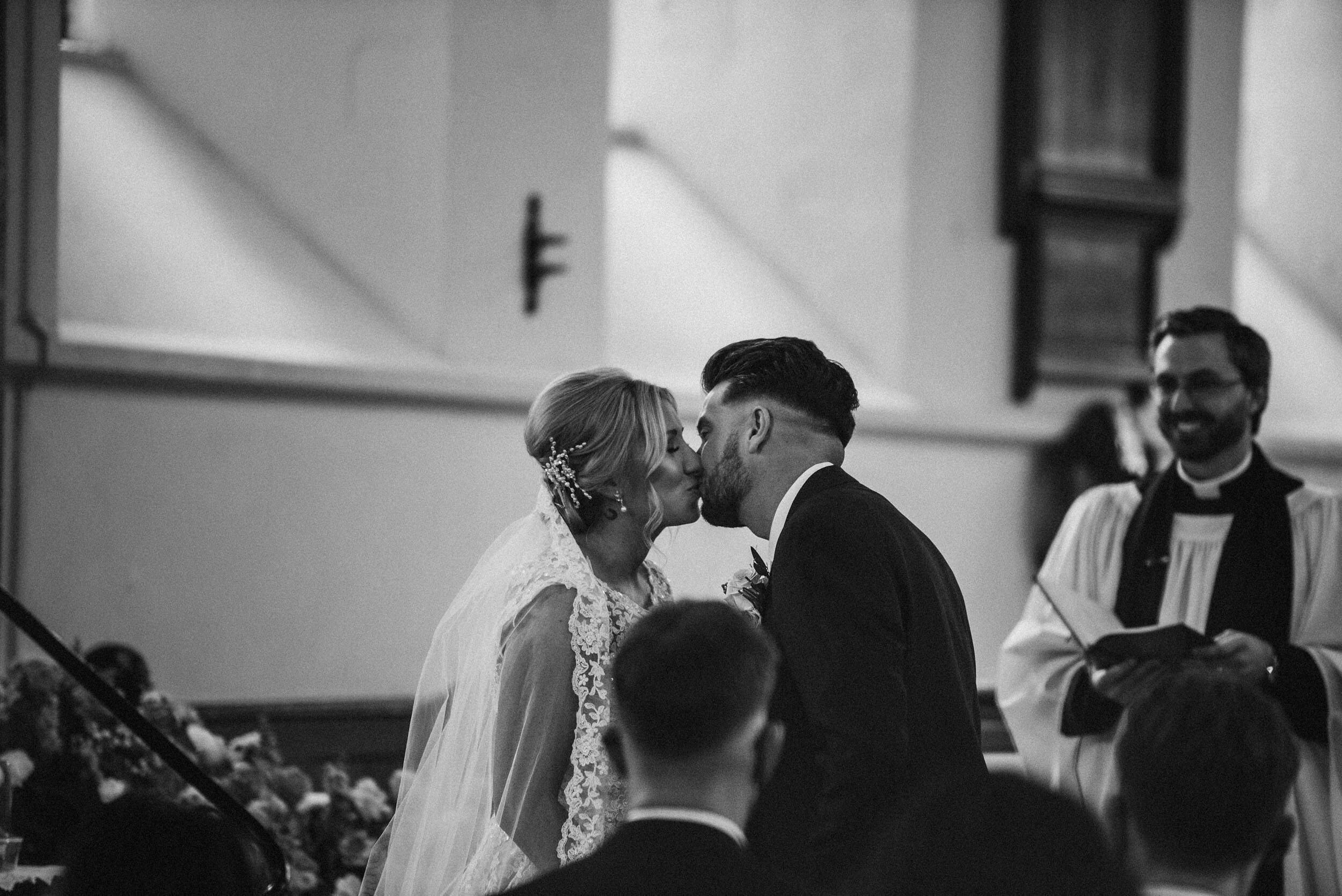 bride and groom kissing in church