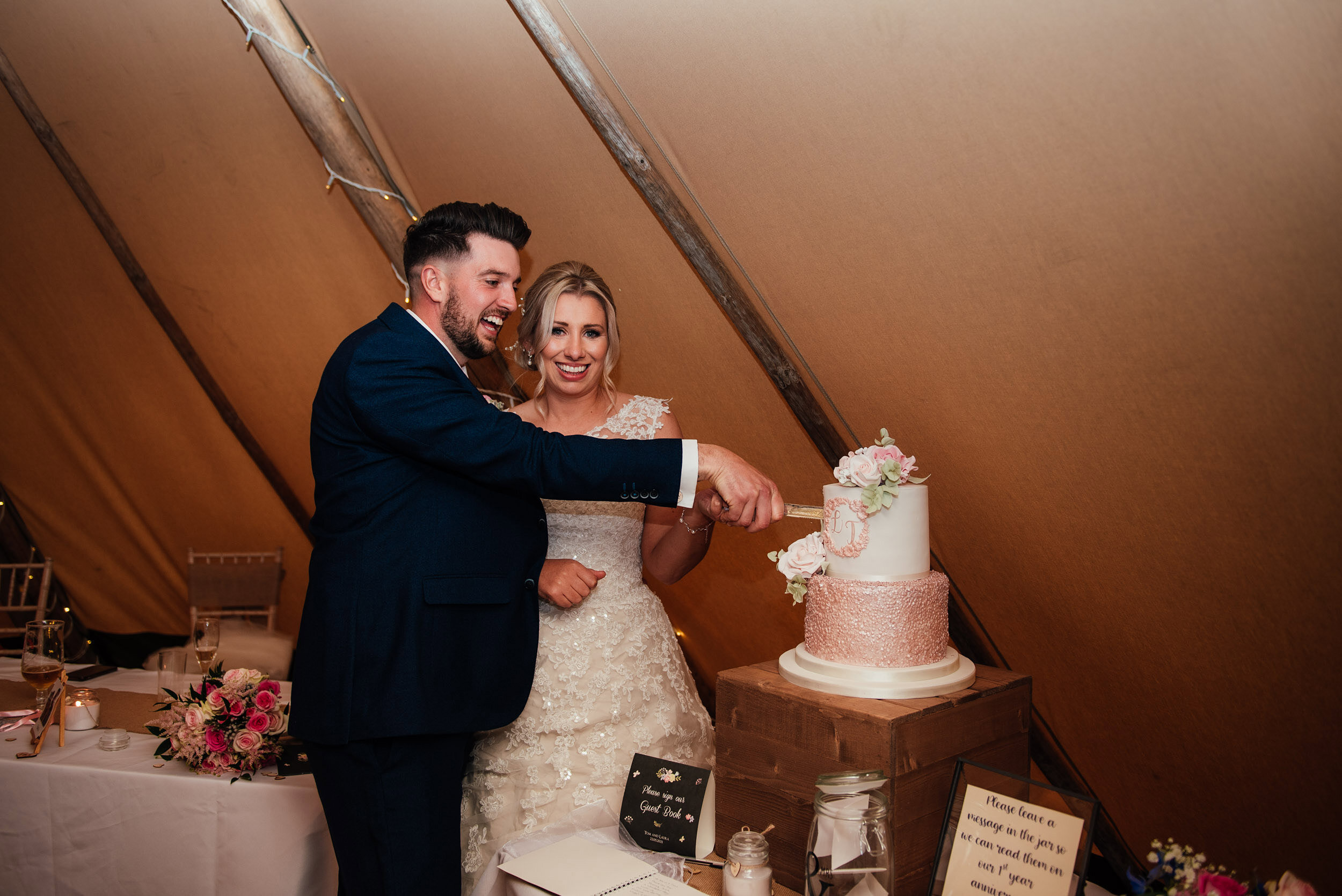 bride and groom cut the wedding cake at the nottingham tipi wedding