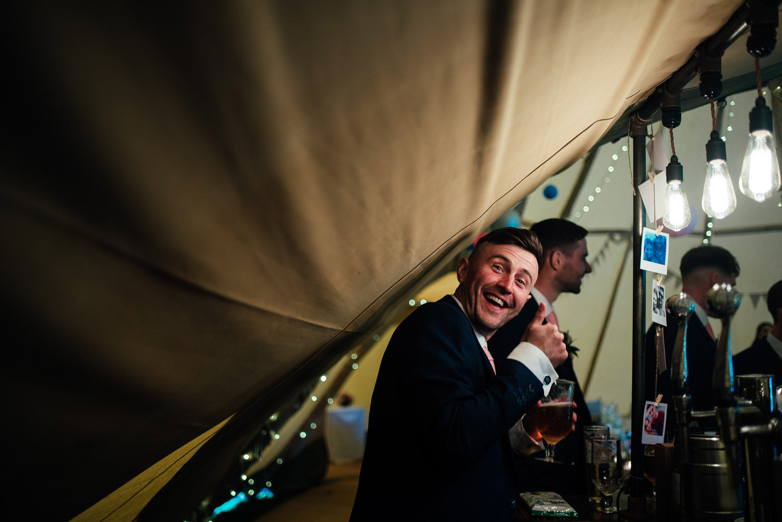 wedding guests helping himself to a pint from the bar