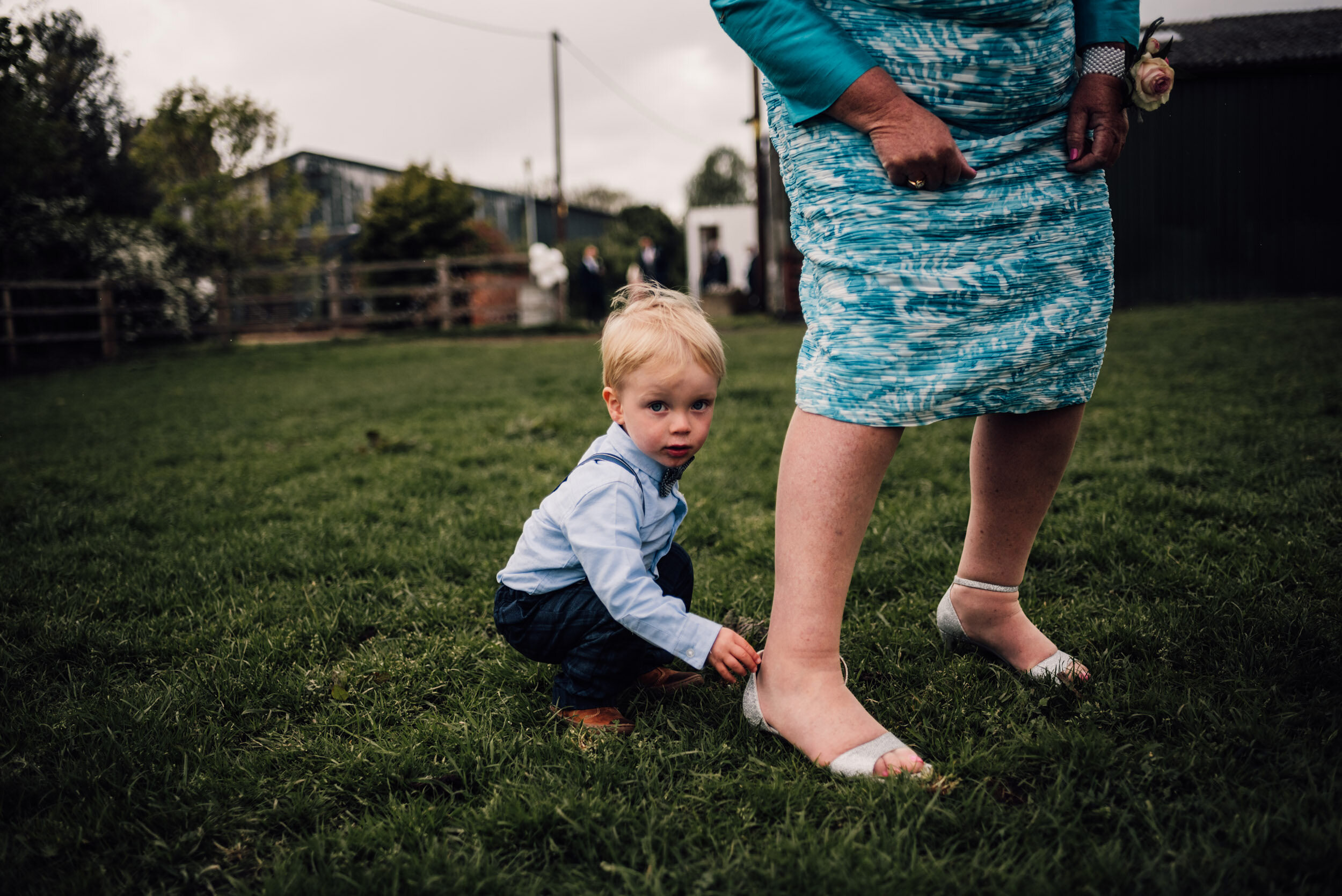 young boy  fixes the strap on his grandma’s shoe