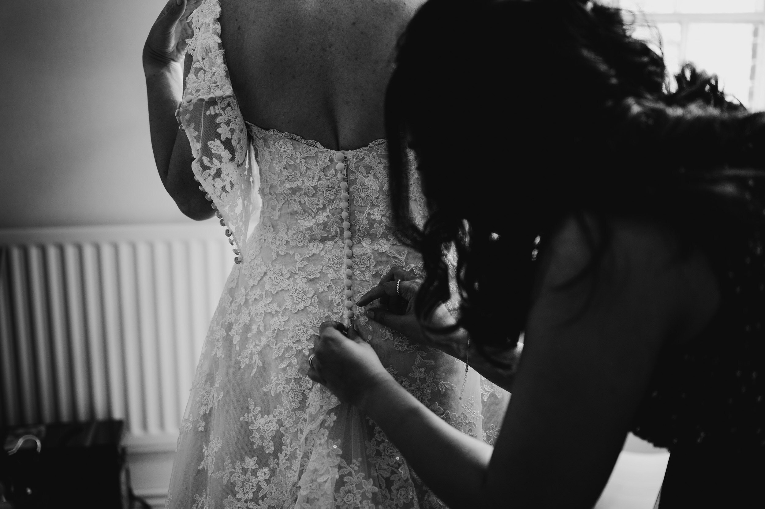 bride putting on wedding dress