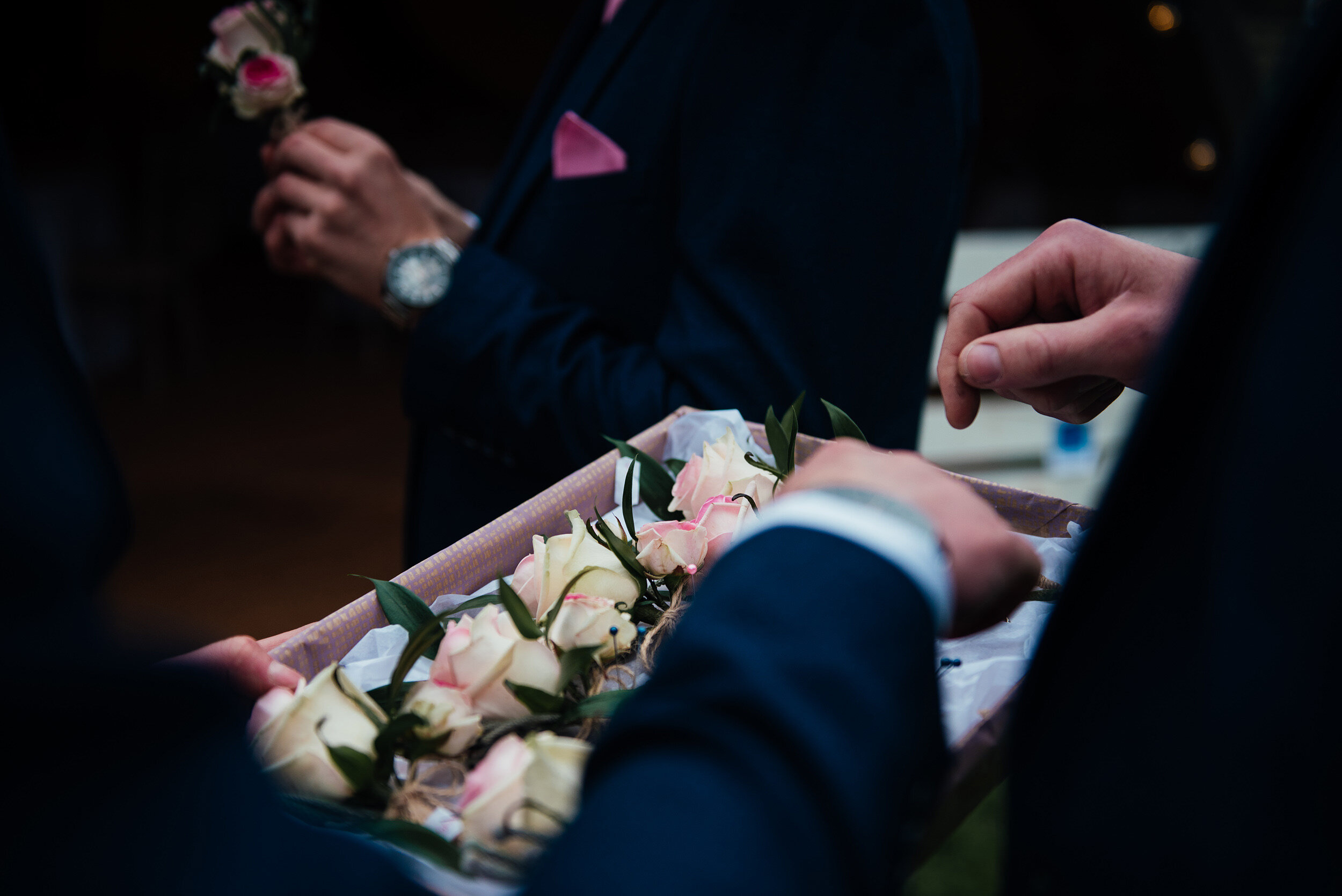 groomsman putting on their button holes