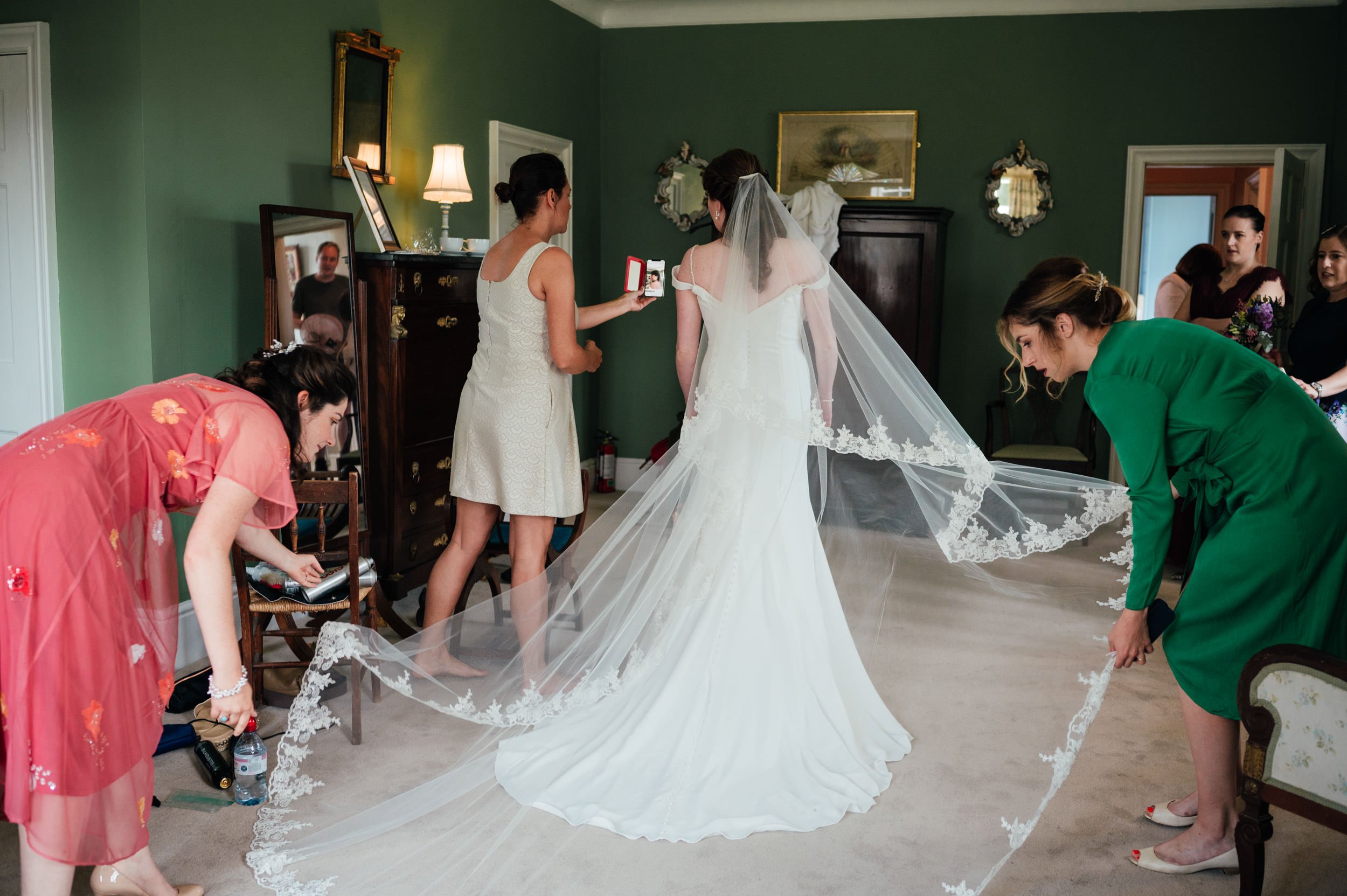 bridesmaids helping the bride put on her veil