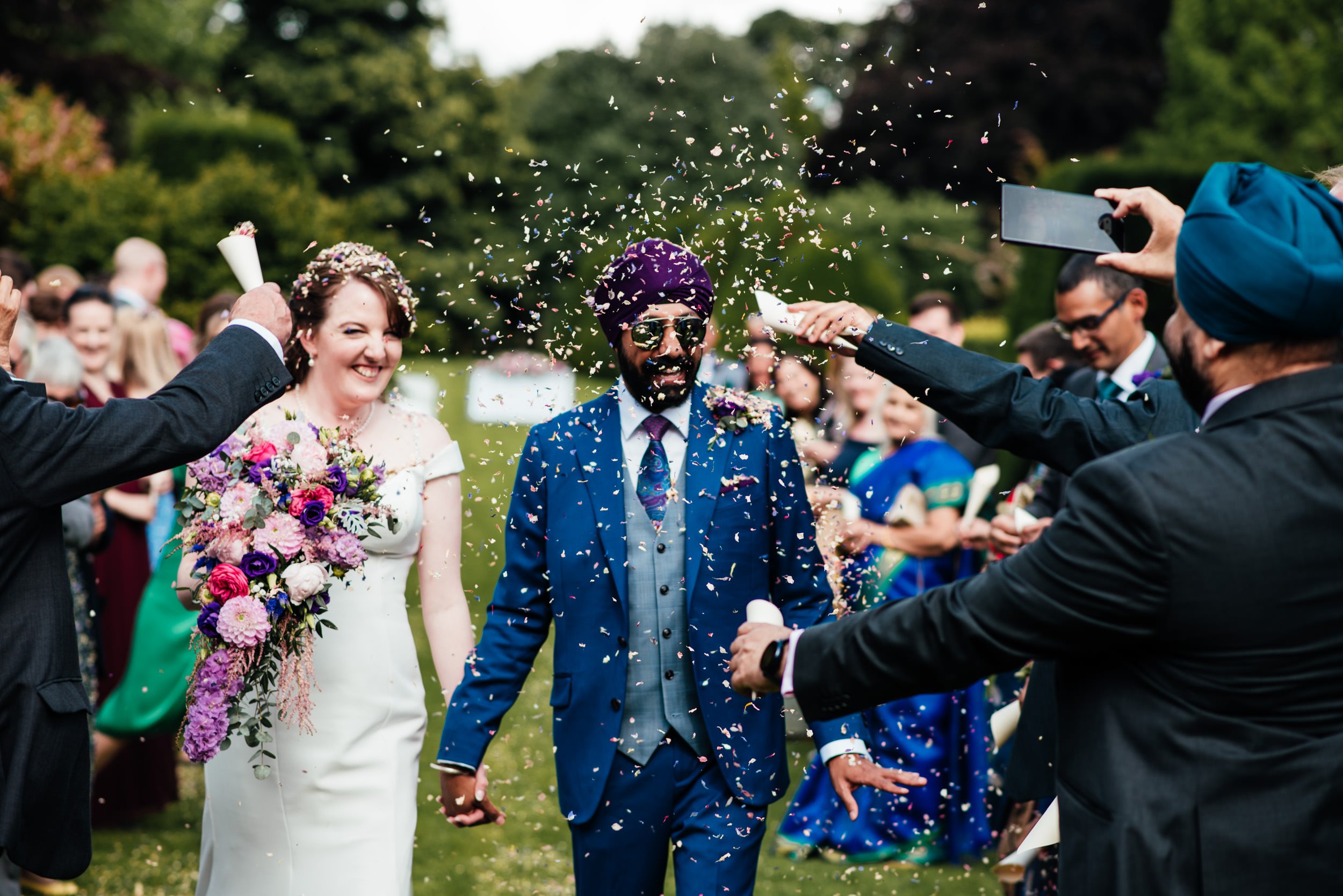 wedding guests throw confetti over the bride and groom at holme pierrepont hall