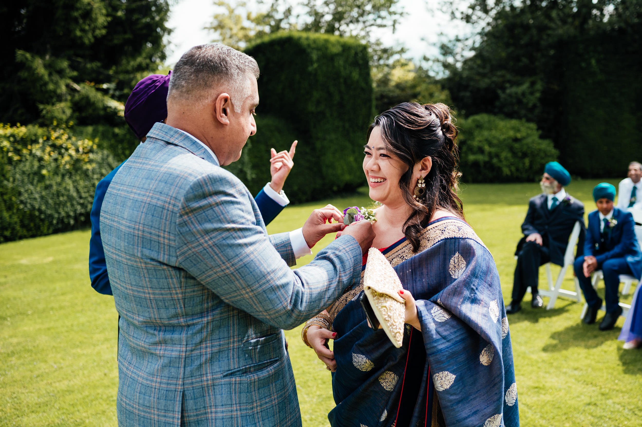 wedding guest pins flower to her dress