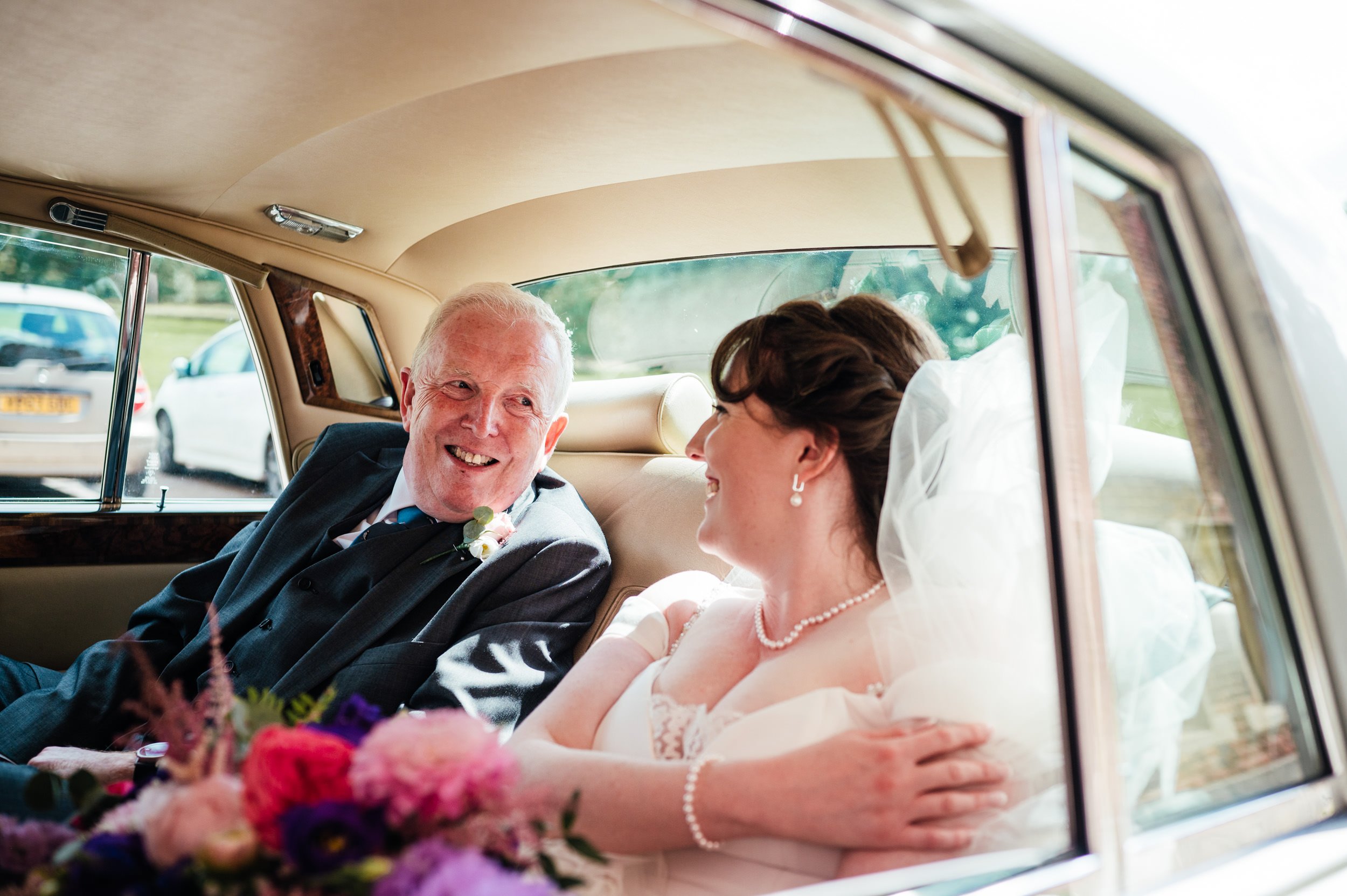 bride and her father smiling at each other