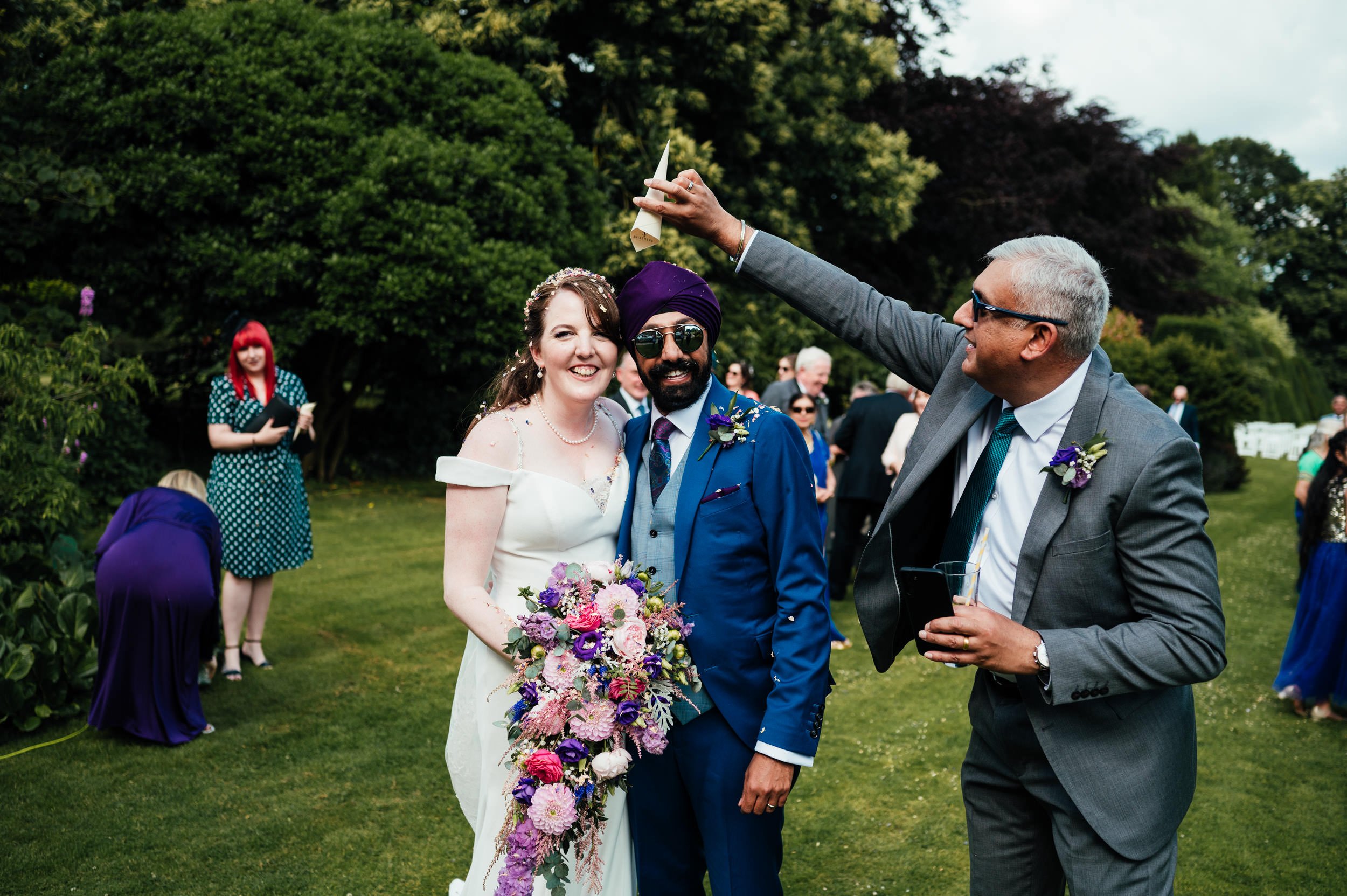 guests throws confetti over the bride and groom