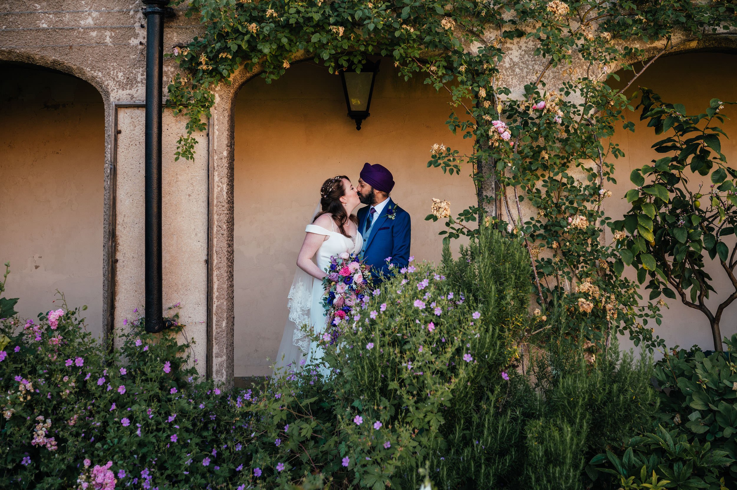 bride and groom kissing in the gardens at holme pierrepont hall