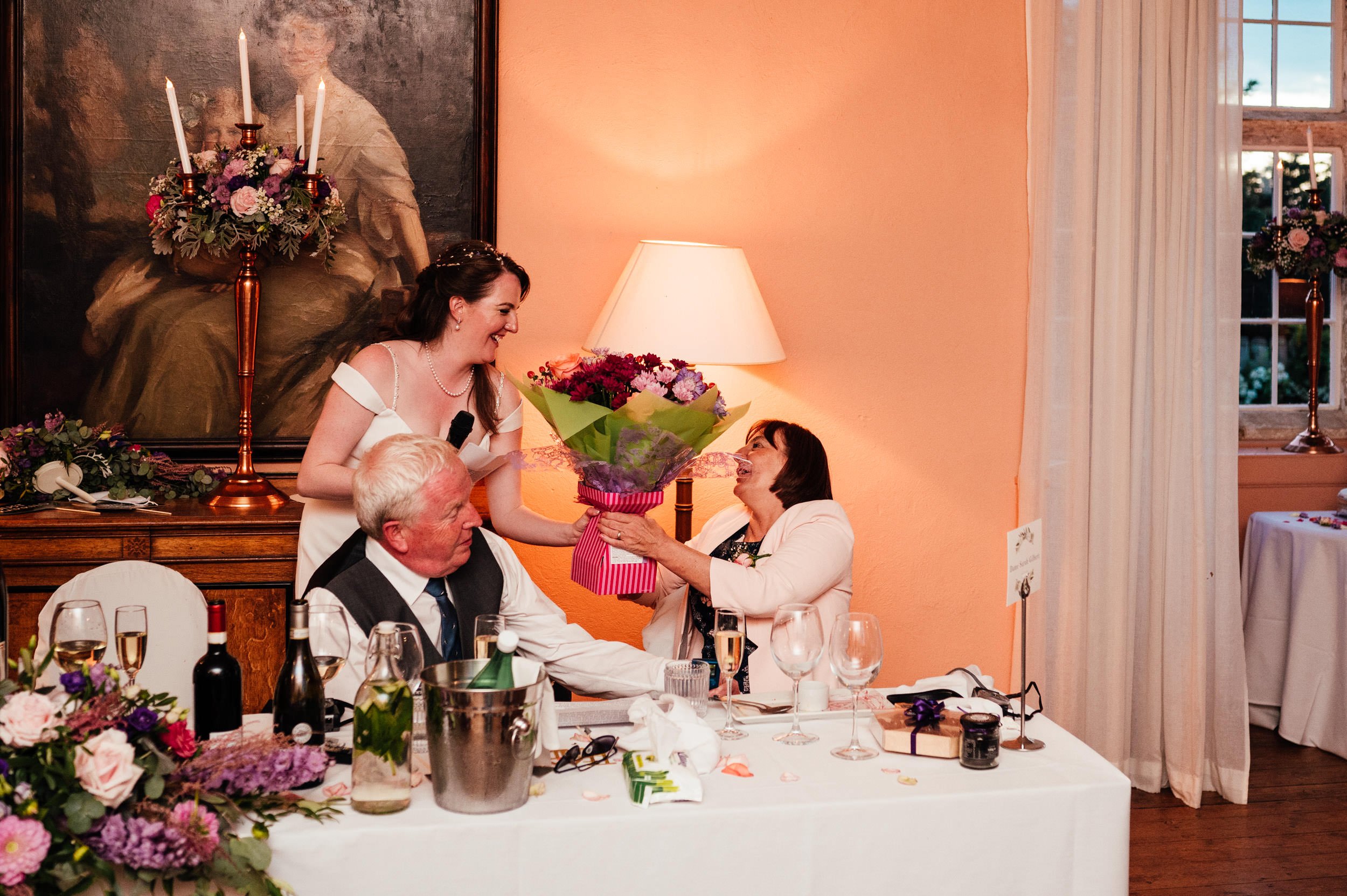 bride gives mum flowers during the wedding speech