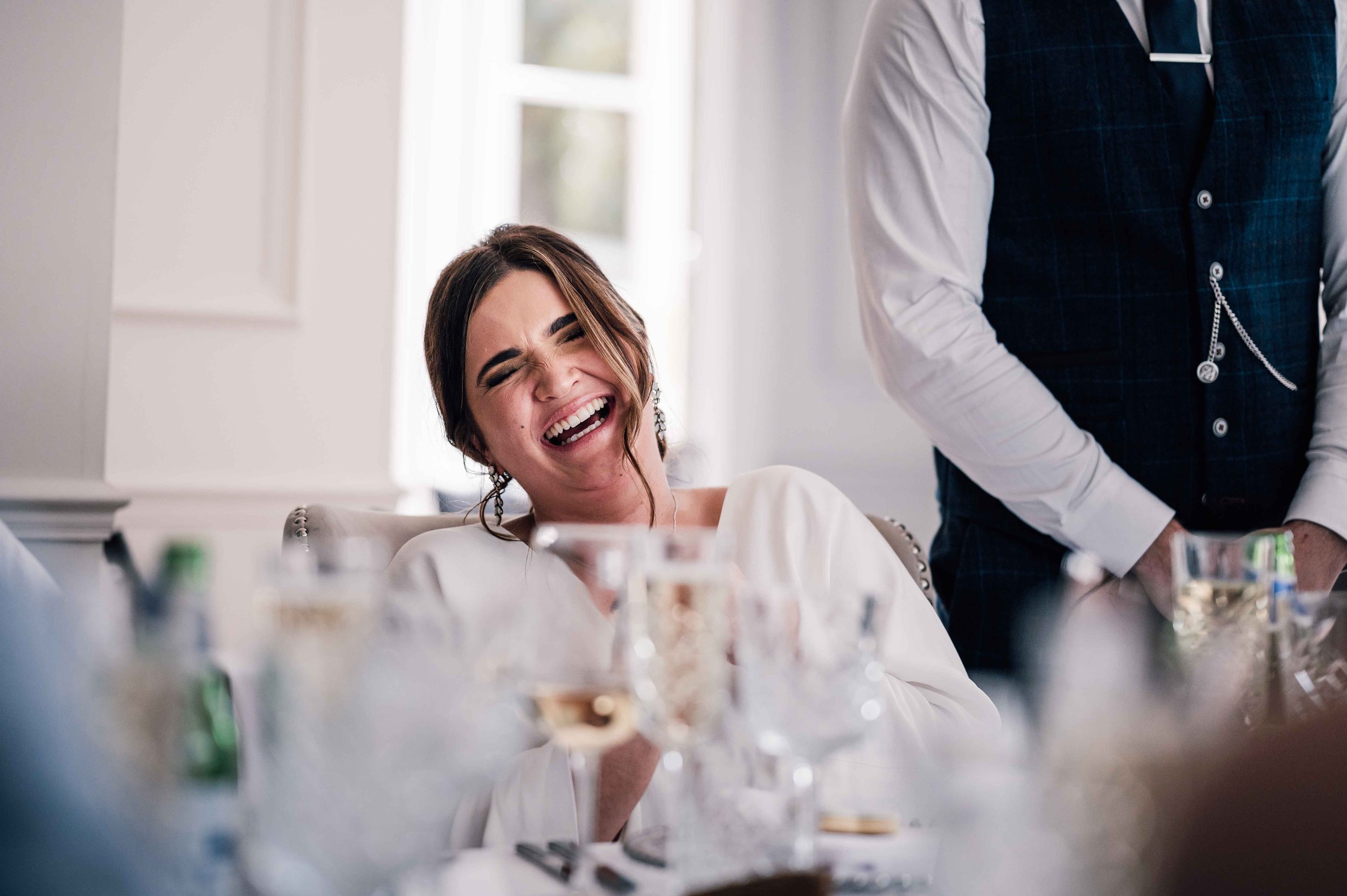 Bride laughing during wedding speeches