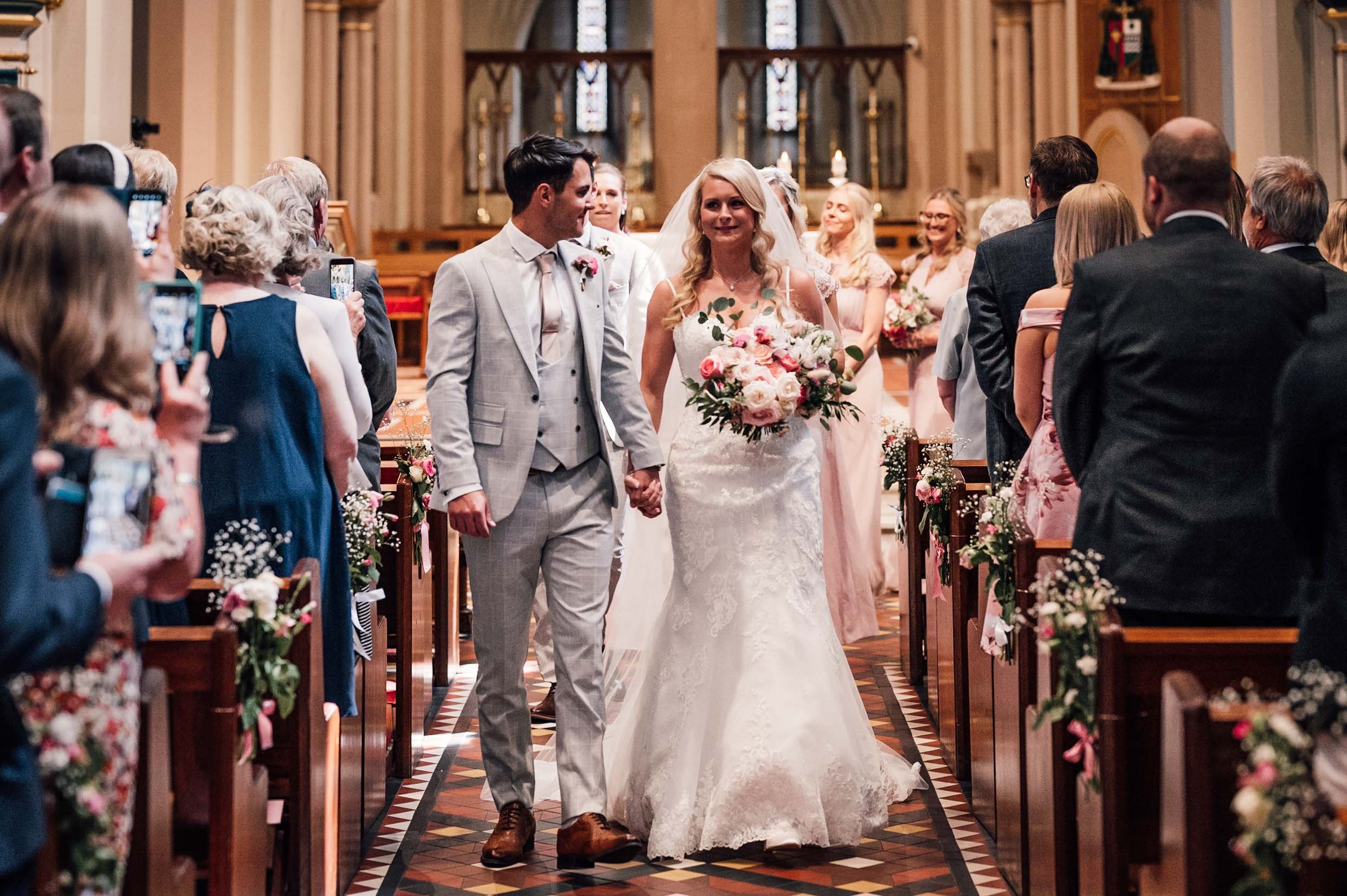 bride and groom walk back down the aisle at St Barnabas cathedral, Nottingham