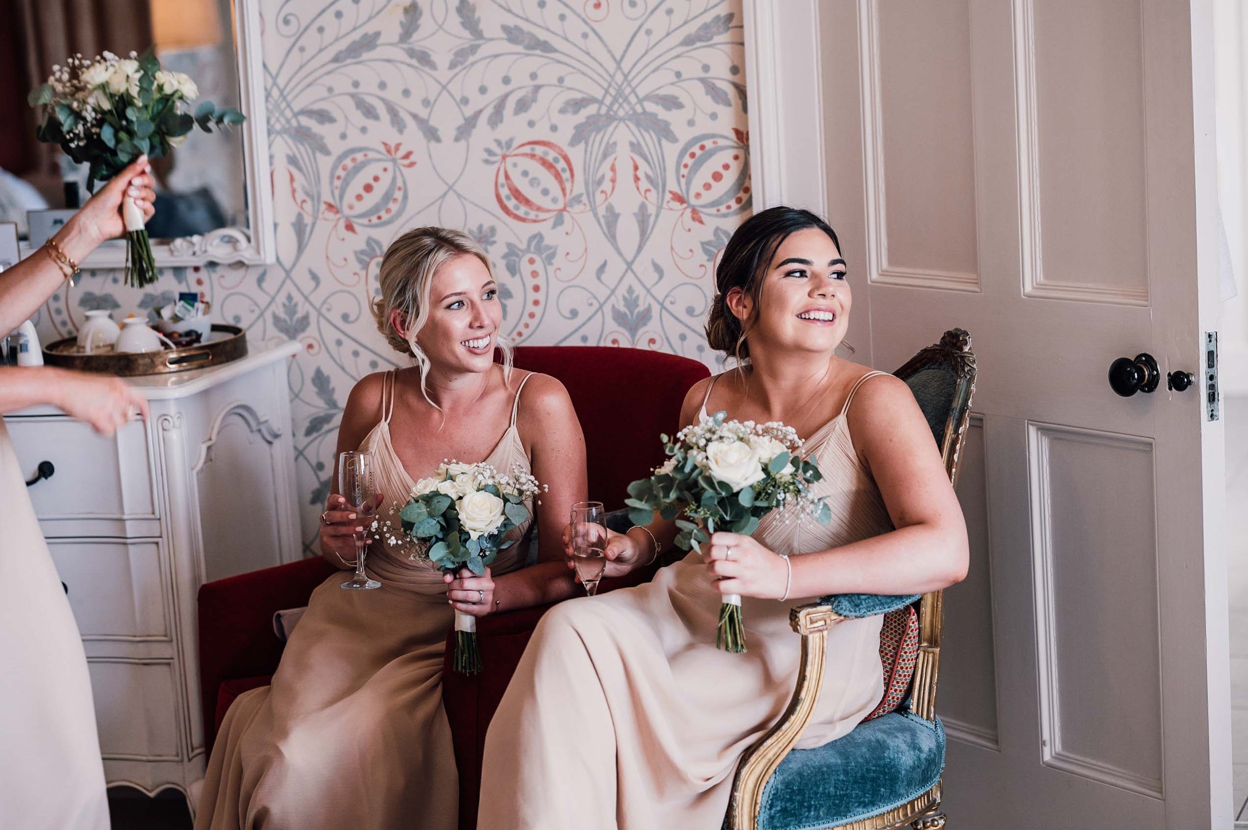 Bridesmaids laughing in the bridal suite at Hodsock Priory