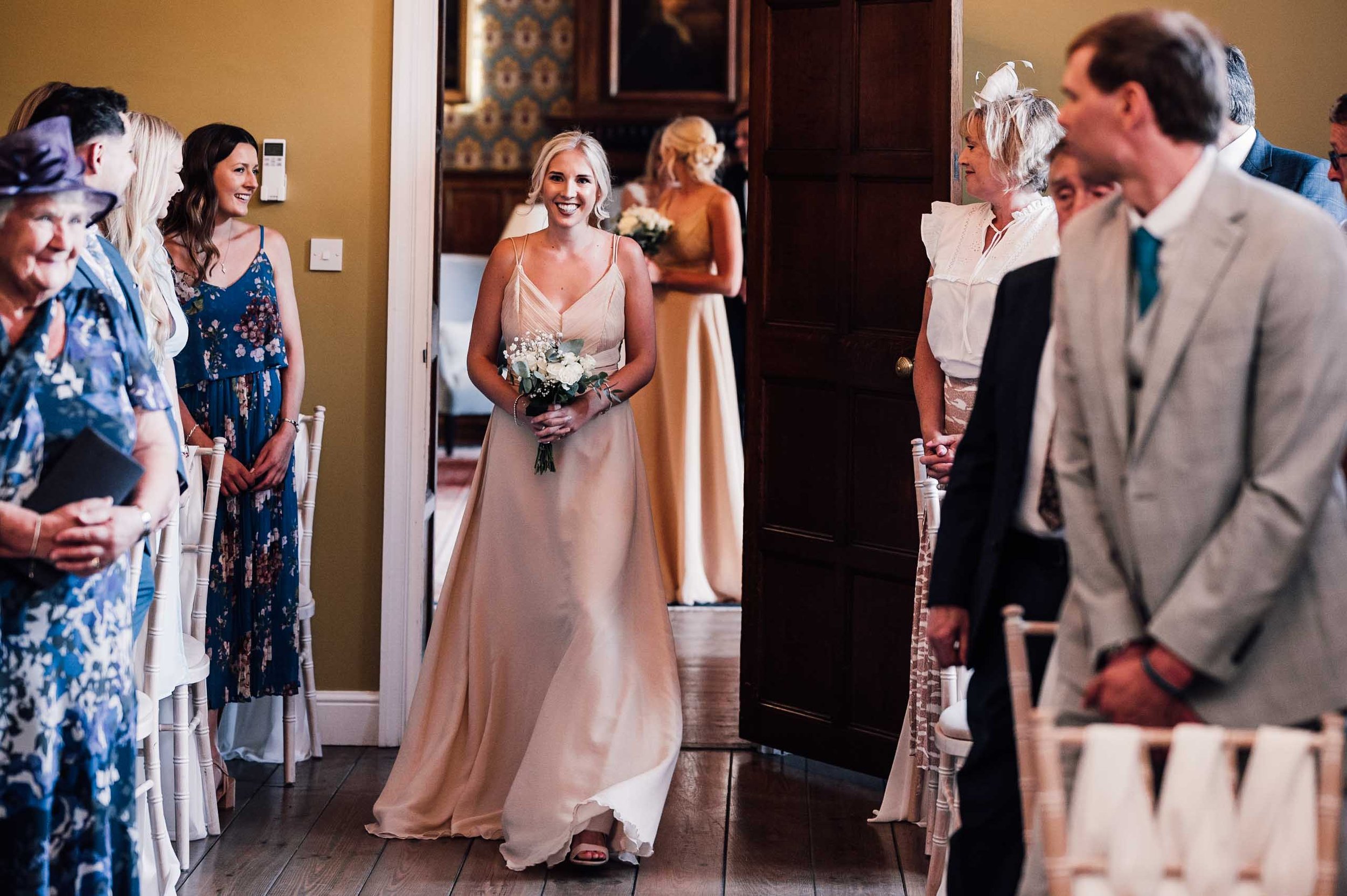 Bridesmaid walking down the aisle at Hodsock Priory