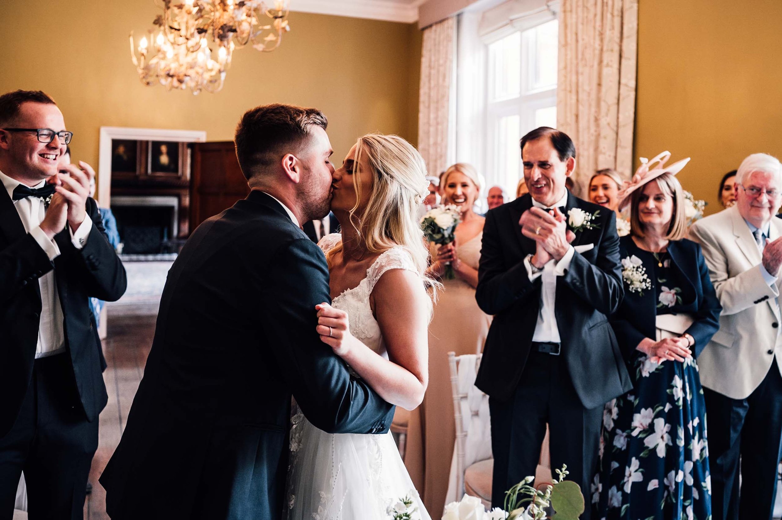 Bride and groom kissing during their wedding ceremony at Hodsock Priory